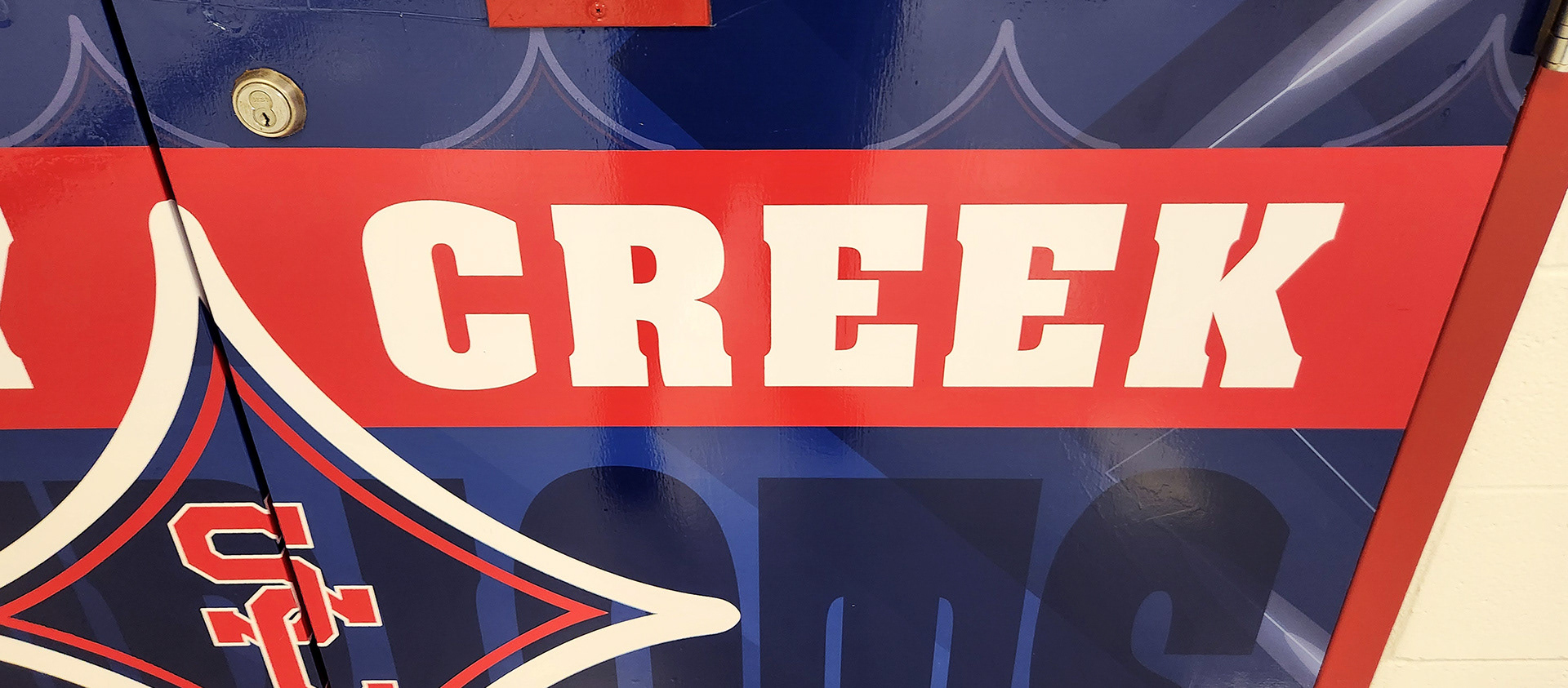 Red, white, and blue adhesive vinyl-covered door branded with an SC logo and the text "Sandy Creek Patriots"
