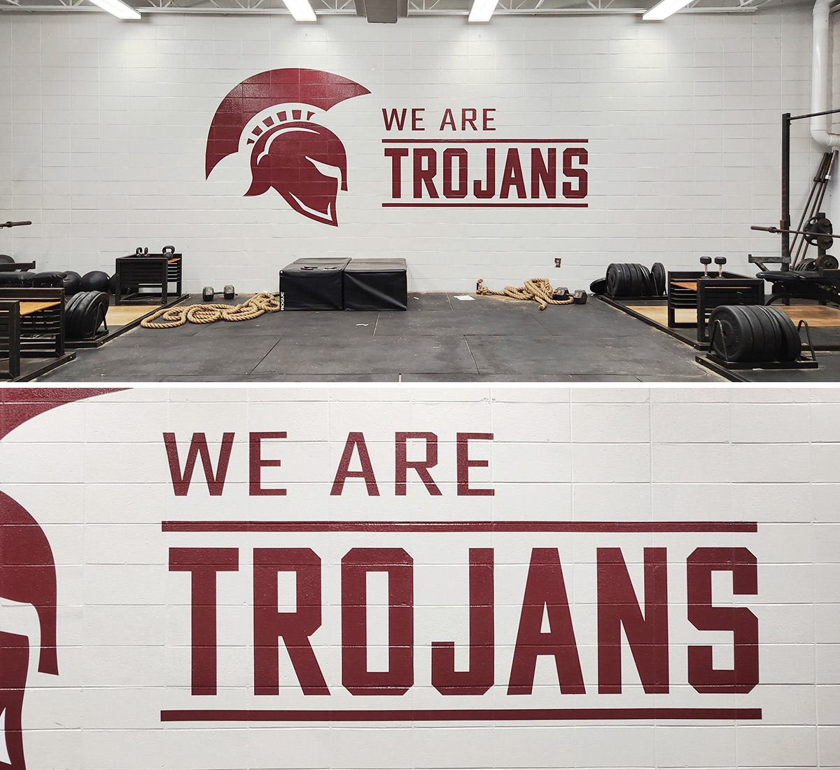 A weight room with a painted white brick wall featuring adhesive vinyl decals. The decals display a Trojan helmet silhouette on the left, with the words 'WE ARE TROJANS' to the right.