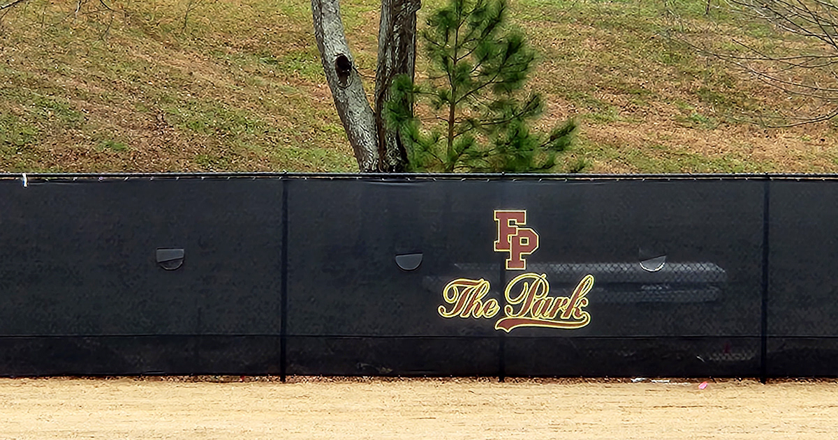 Black fence windscreen with half-moon vents, featuring the 'FP' logo above the text 'The Park' in cursive, both printed in maroon ink outlined in yellow.