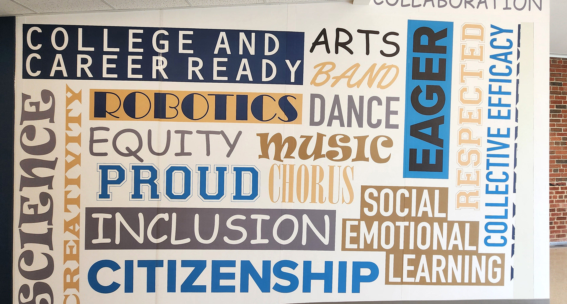 A floor-to-ceiling adhesive vinyl wall mural featuring a word grid with the words 'COLLEGE AND CAREER', 'ARTS', 'BAND', 'DANCE', 'MUSIC', 'CHORUS', 'SOCIAL EMOTIONAL LEARNING', 'EAGER', 'RESPECTED', 'COLLECTIVE EFFICACY', 'SCIENCE', 'CREATIVITY', 'ROBOTICS', 'EQUITY', 'PROUD', 'INCLUSIVE', and 'CITIZEN' in various colors and fonts over a white background. 