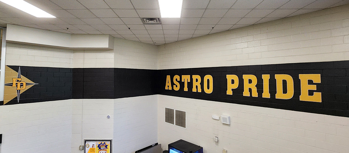 a full print adhesive banner black with yellow lettering with a white outline reading 'astro pride' and black a four point star outlined in white over a tan triangle and under yellow lettering with a white outline reading 'FD'