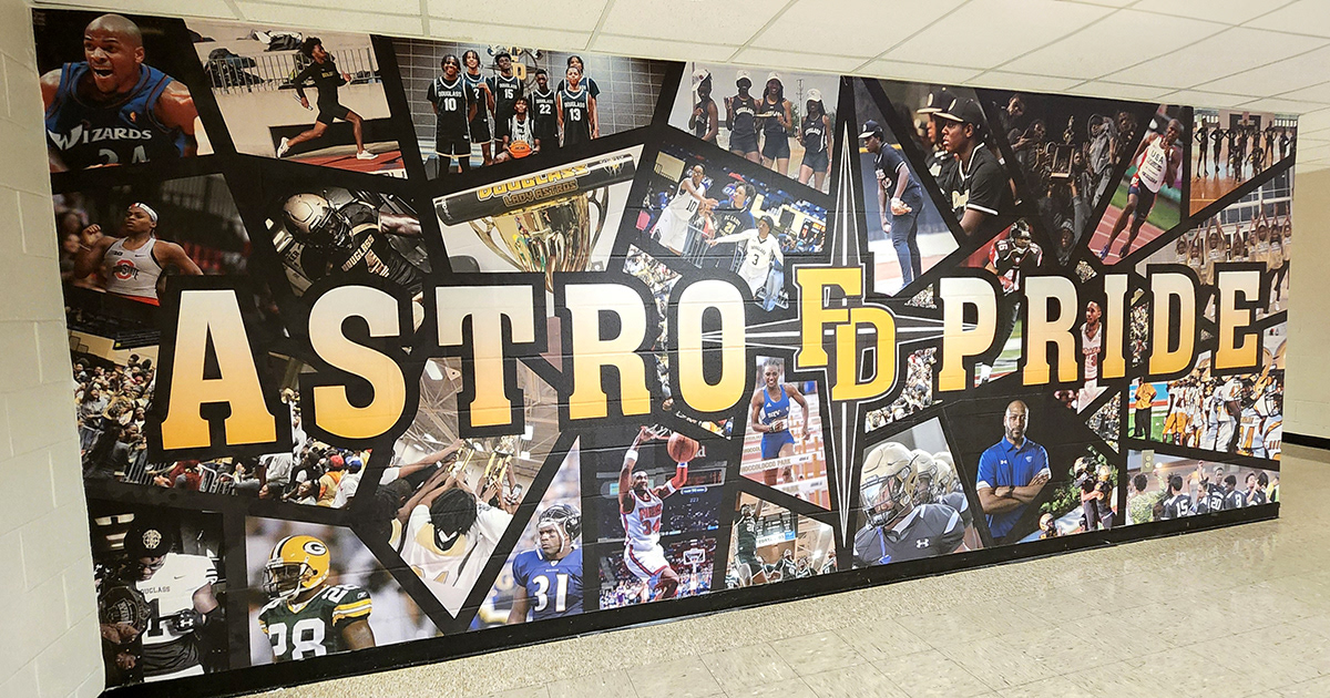 full print adhesive wall mural featuring a collage school themed sports images, overlayed with yellow text with a black outline reading 'Astro FD Pride'