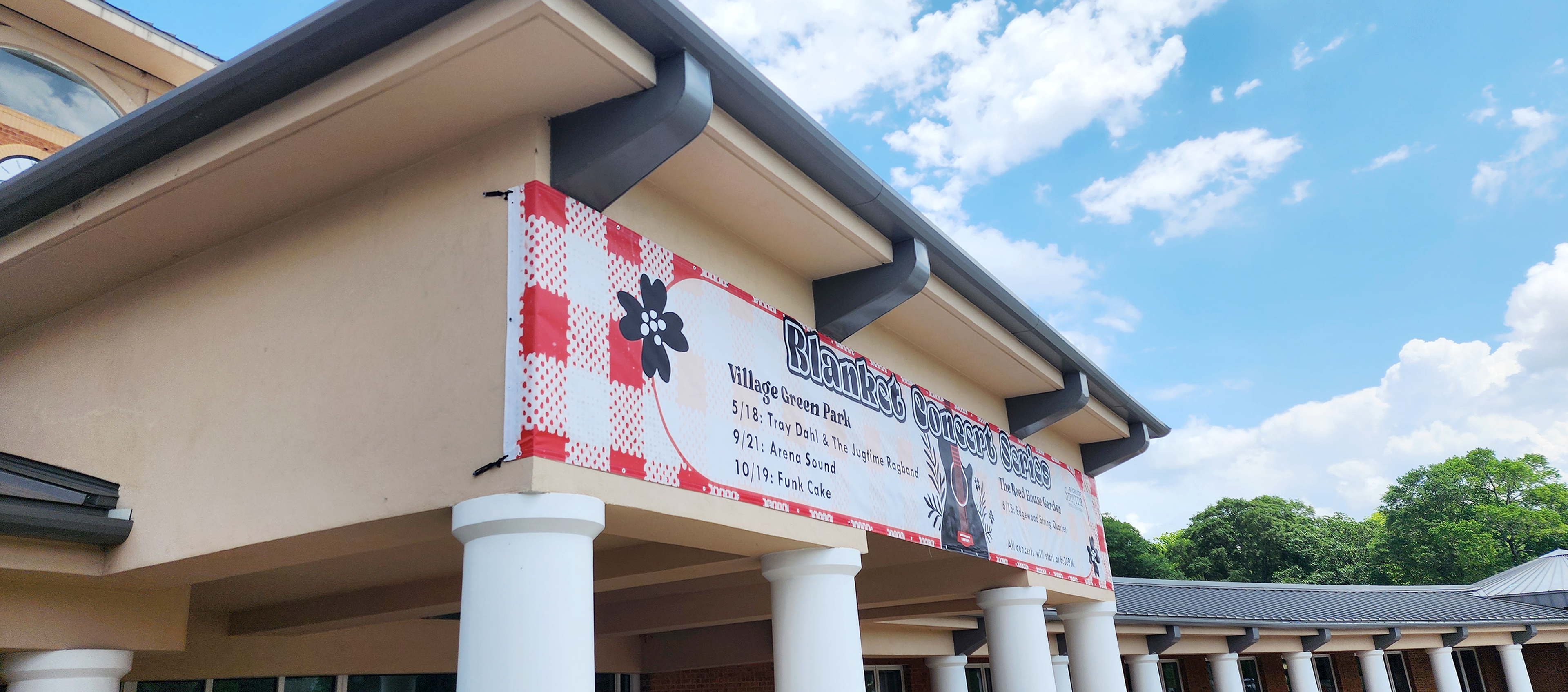 Printed vinyl banner for a concert series affixed to the front entrance of a building.