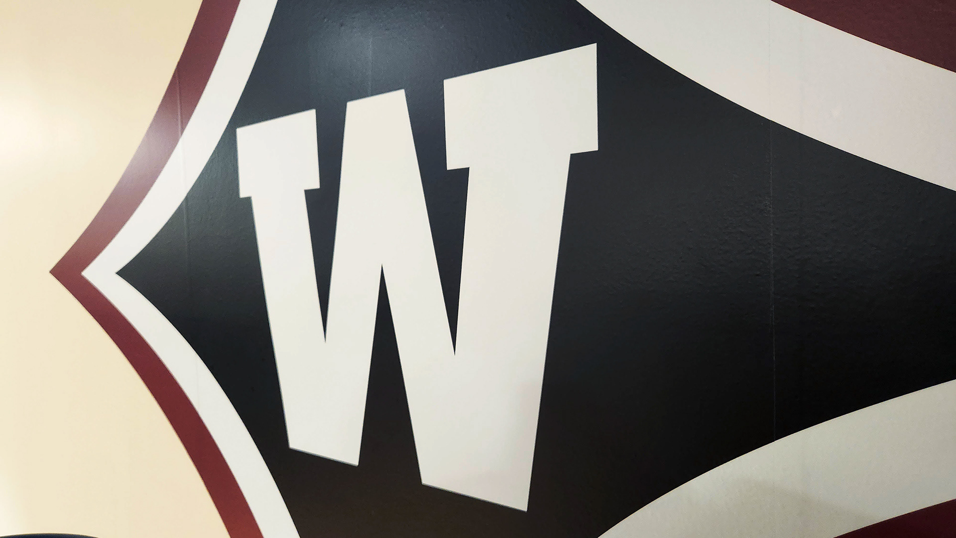 A large adhesive vinyl navy four-point star logo, outlined in white and then red, with a 'W' in the center of the star.