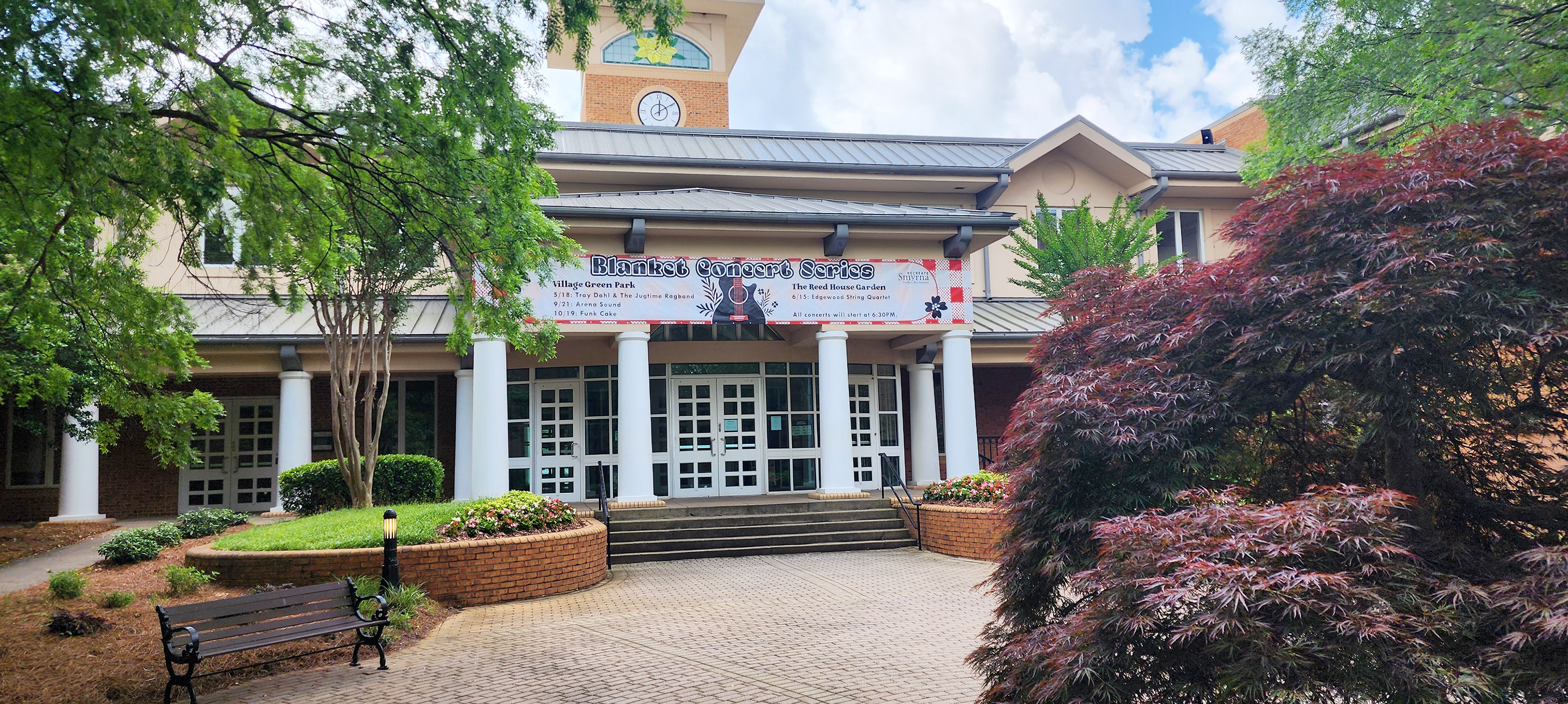 Printed vinyl banner for a concert series affixed to the front entrance of a building.