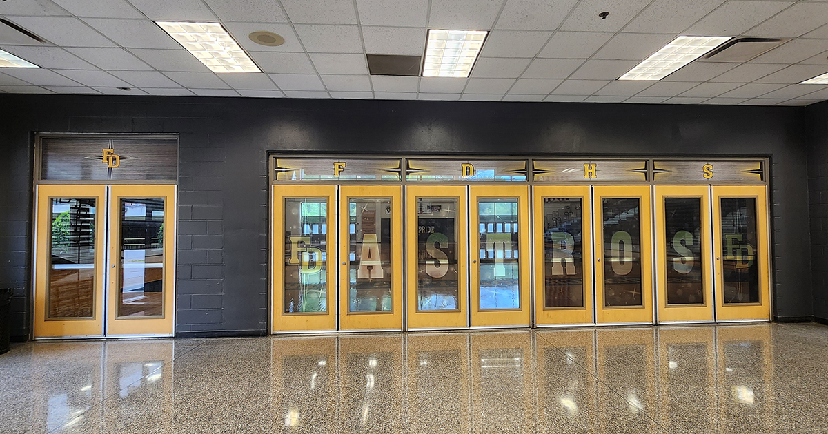 full print window perf with a grey background under a black four point star outlined in white under yellow lettering with a white outline reading 'FD' and 'FDHS' above the doors, and 'FD' 'ASTROS' 'FD' on the doors