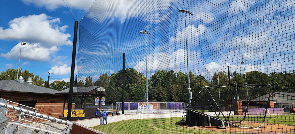 Black sideline sports netting surrounding a baseball field, positioned behind a baseball turtle.
