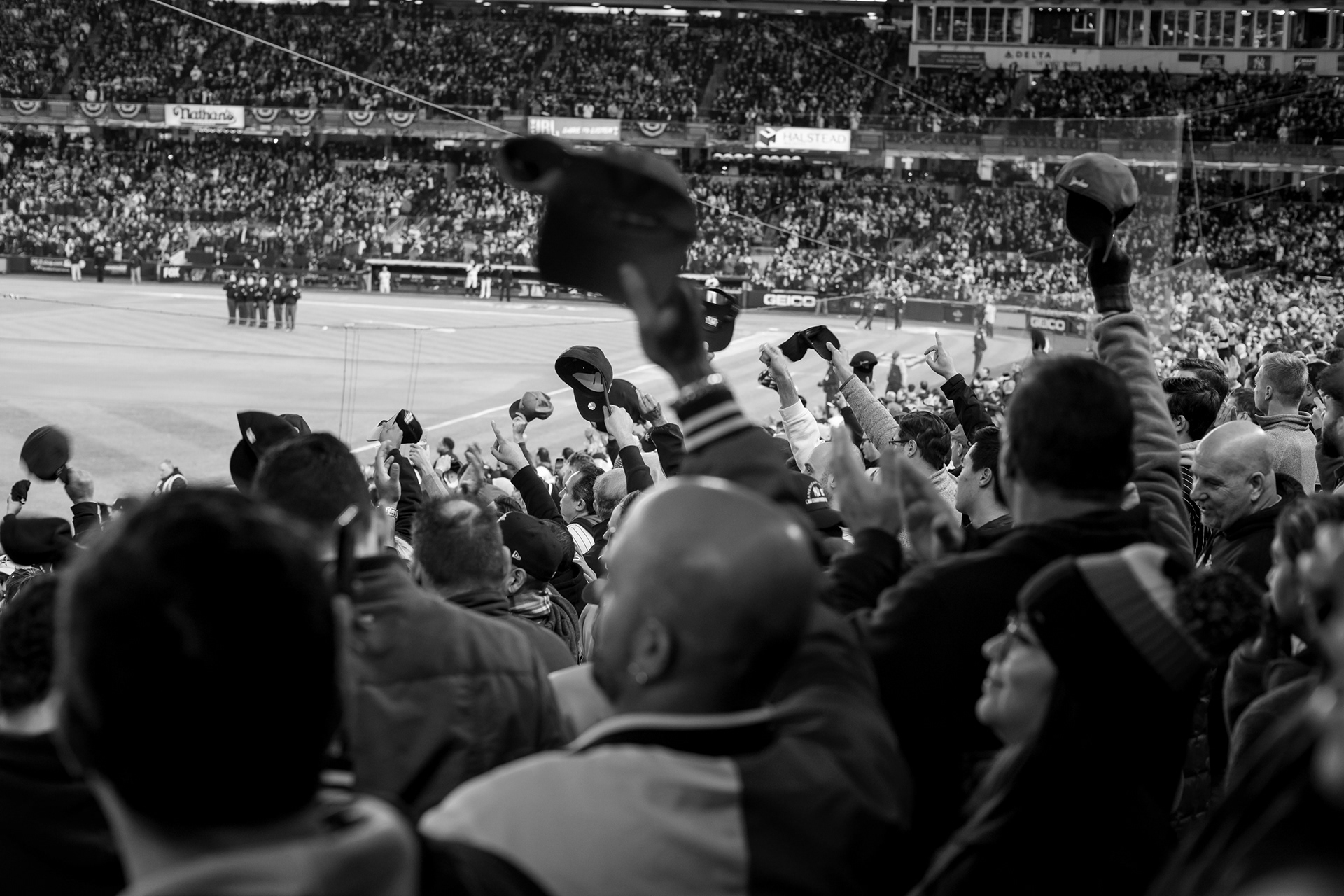 Bronx, New York — October 18th, 2019. Umpires line up and fans remove their caps for the singing of God Bless America and the honoring of a military veteran.