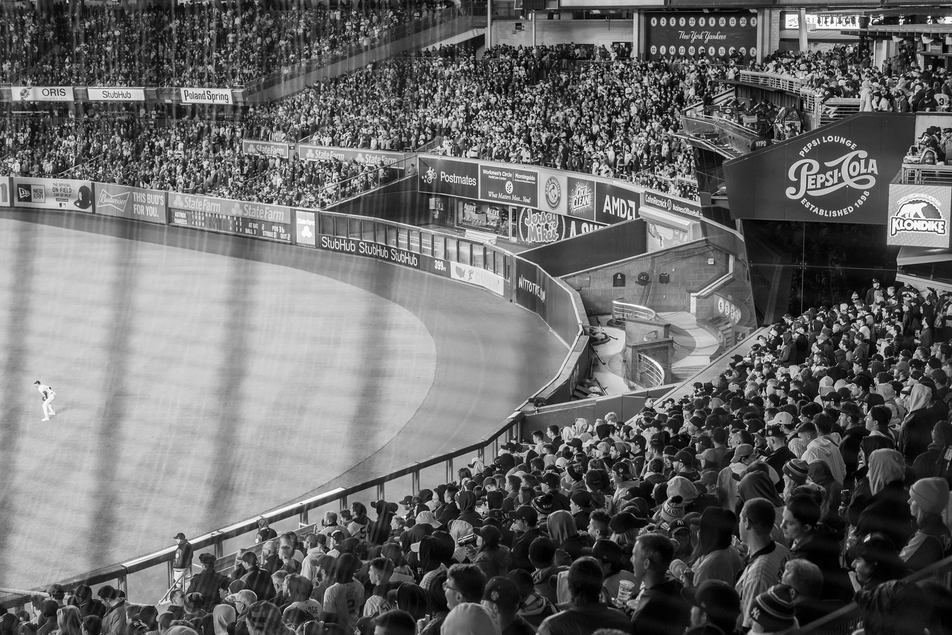 Bronx, New York — October 18th, 2019. Aaron Hicks (left) and the bleachers of Yankee Stadium.