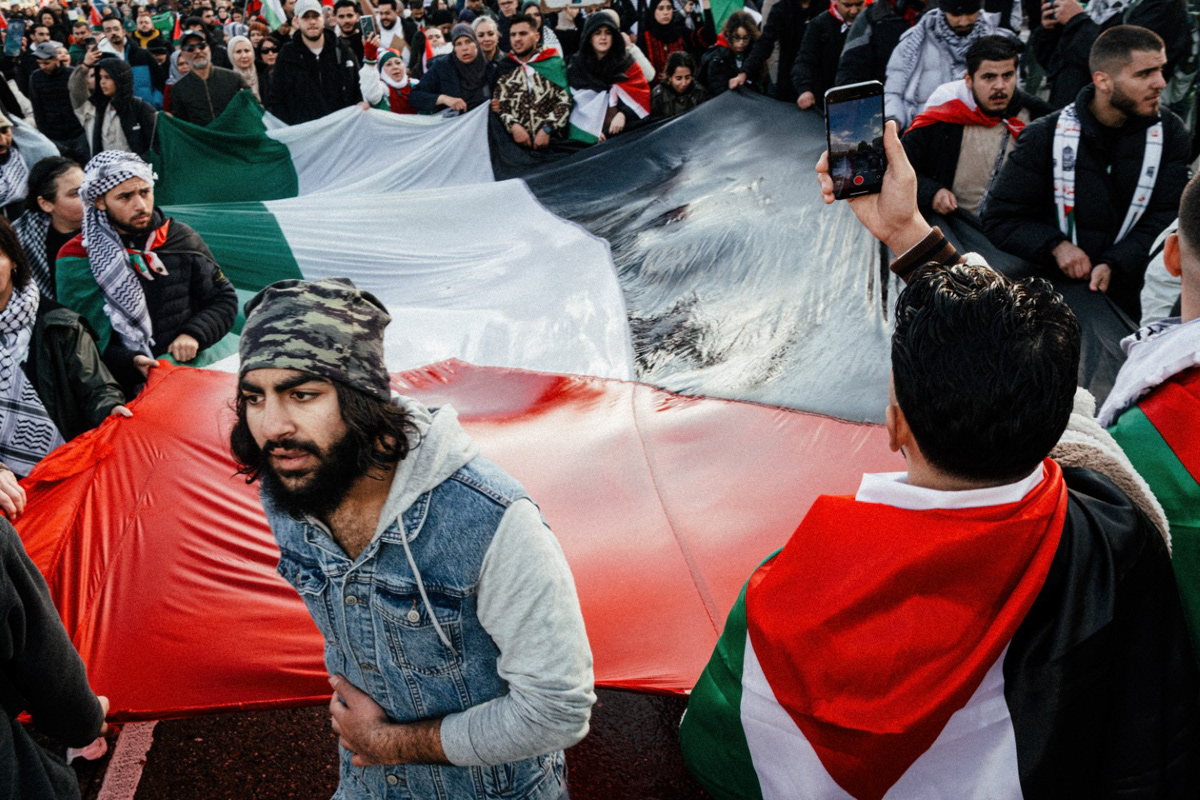 Protesters carry a Palestinian flag through Amsterdam in response to Israeli bombardments of Gaza, 2023