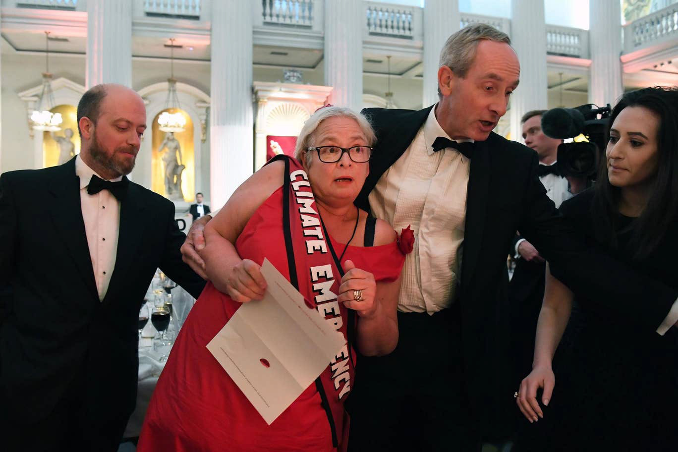 Volunteer wearing campaign outfit is escorted out of Mansion House after interrupting chancellor's speech to deliver climate emergency message