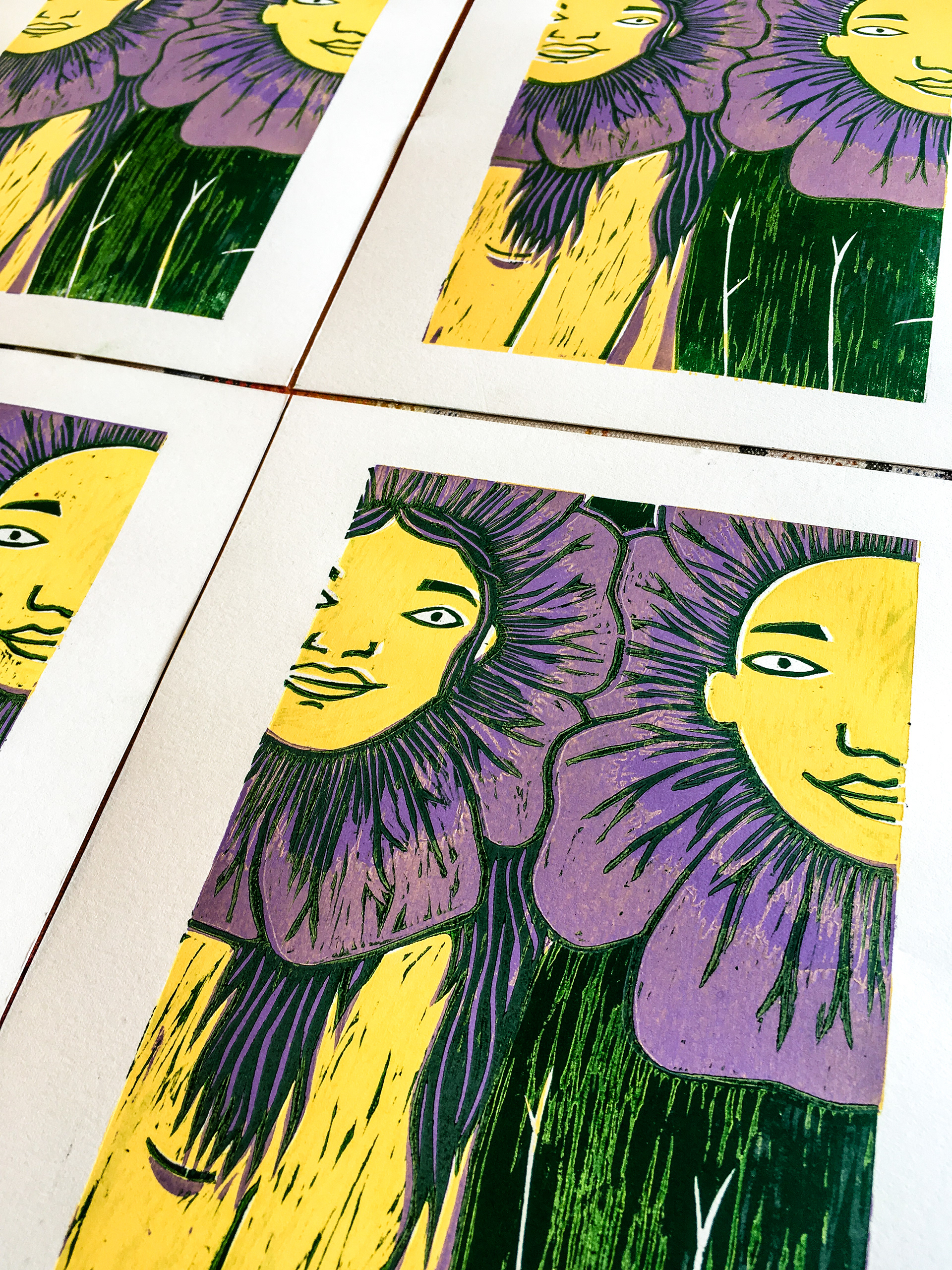 Close-up photograph of four prints  - two people smiling and flowering