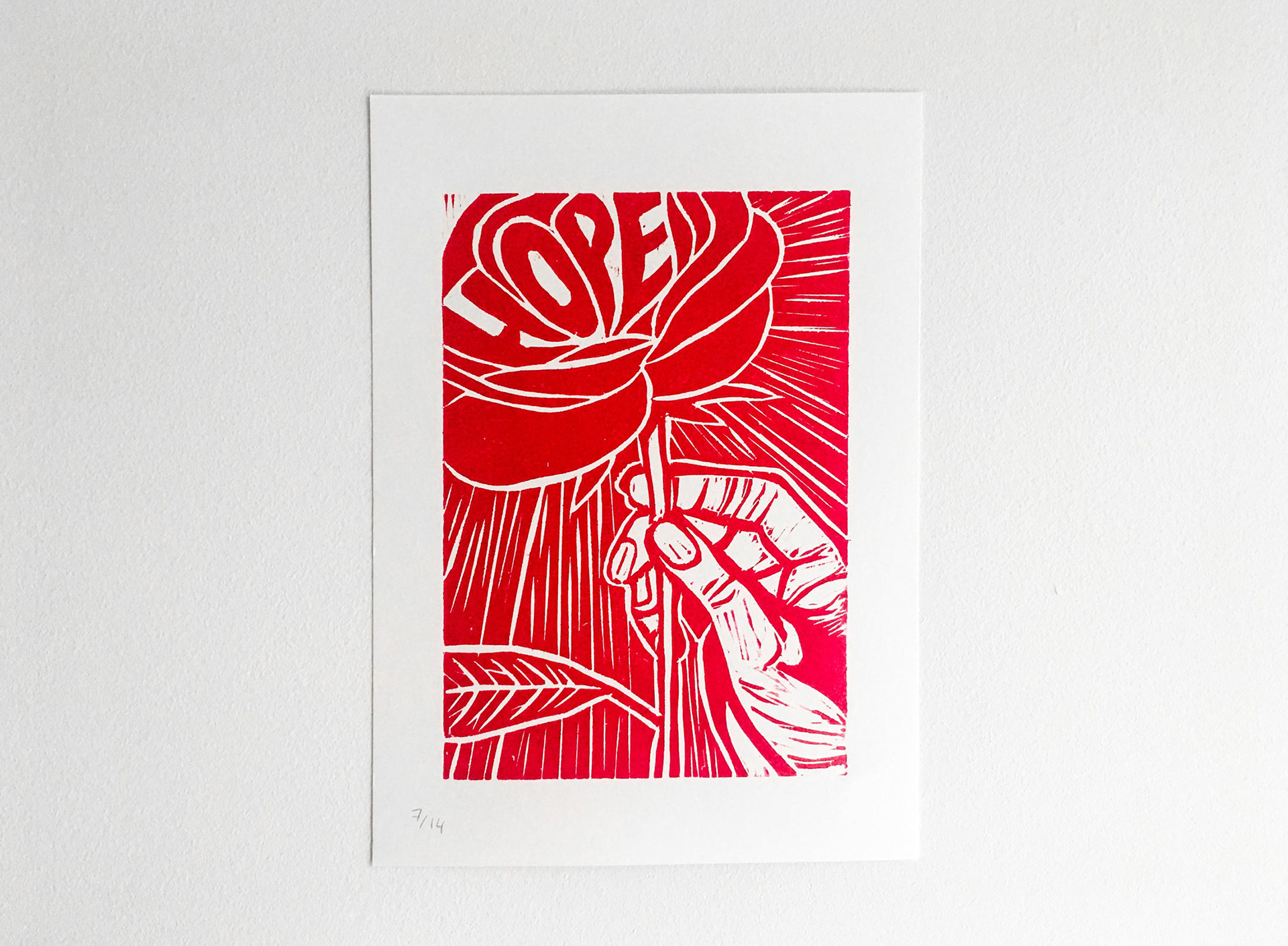 Photo of woodcut print - a hand holding a flower with the word Hope as petals