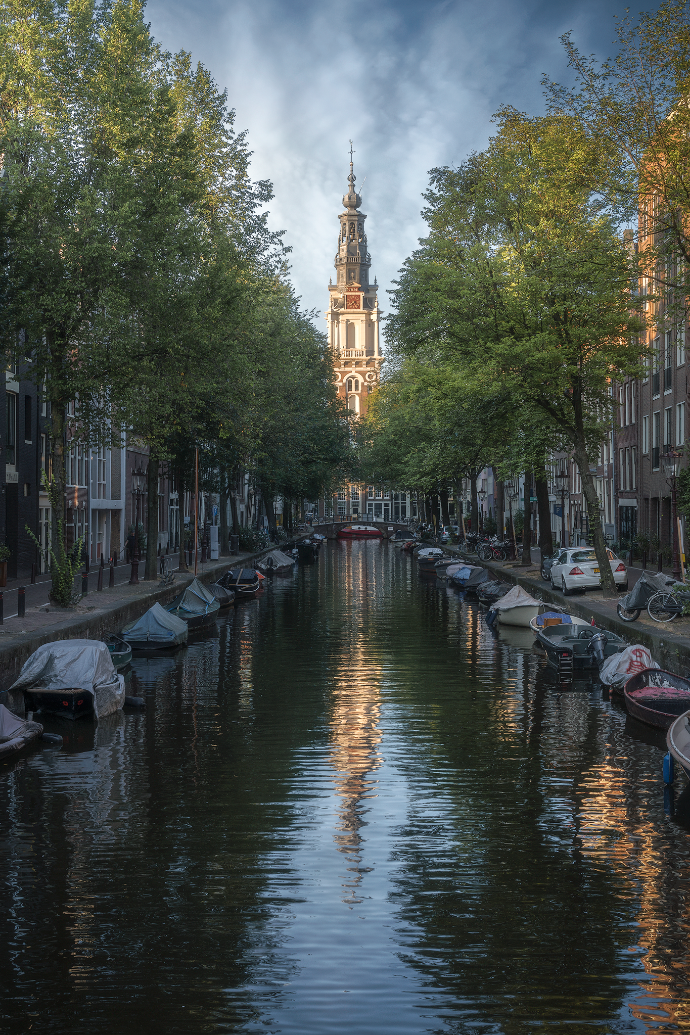 Canale immerso nella quiete mattutina – Uno scorcio pittoresco della città all’alba, con la luce soffusa che illumina l’acqua e gli alberi che incorniciano il paesaggio.
