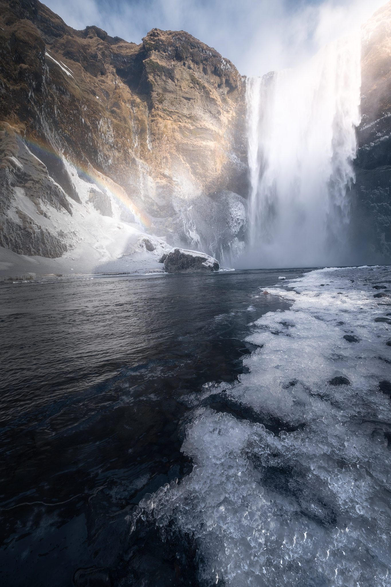 Dettaglio di Skógafoss con ghiaccio – La cascata in pieno inverno, con dettagli del ghiaccio sulle rocce e l’acqua che scorre impetuosa.