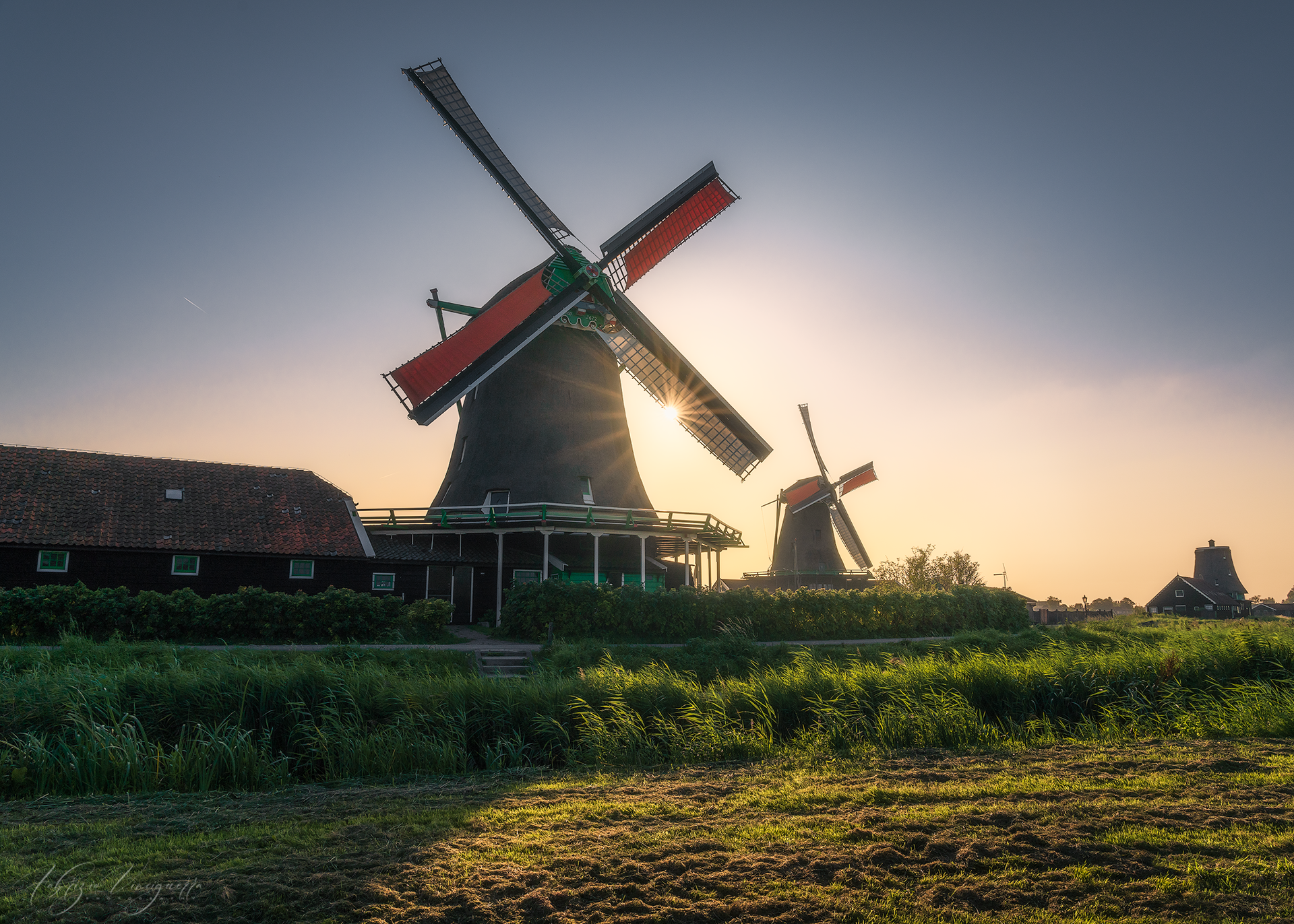 Mulino a vento olandese al tramonto – Un’icona dei Paesi Bassi, il mulino si staglia contro il cielo sfumato dai colori del tramonto, evocando la tradizione e la serenità della campagna olandese.