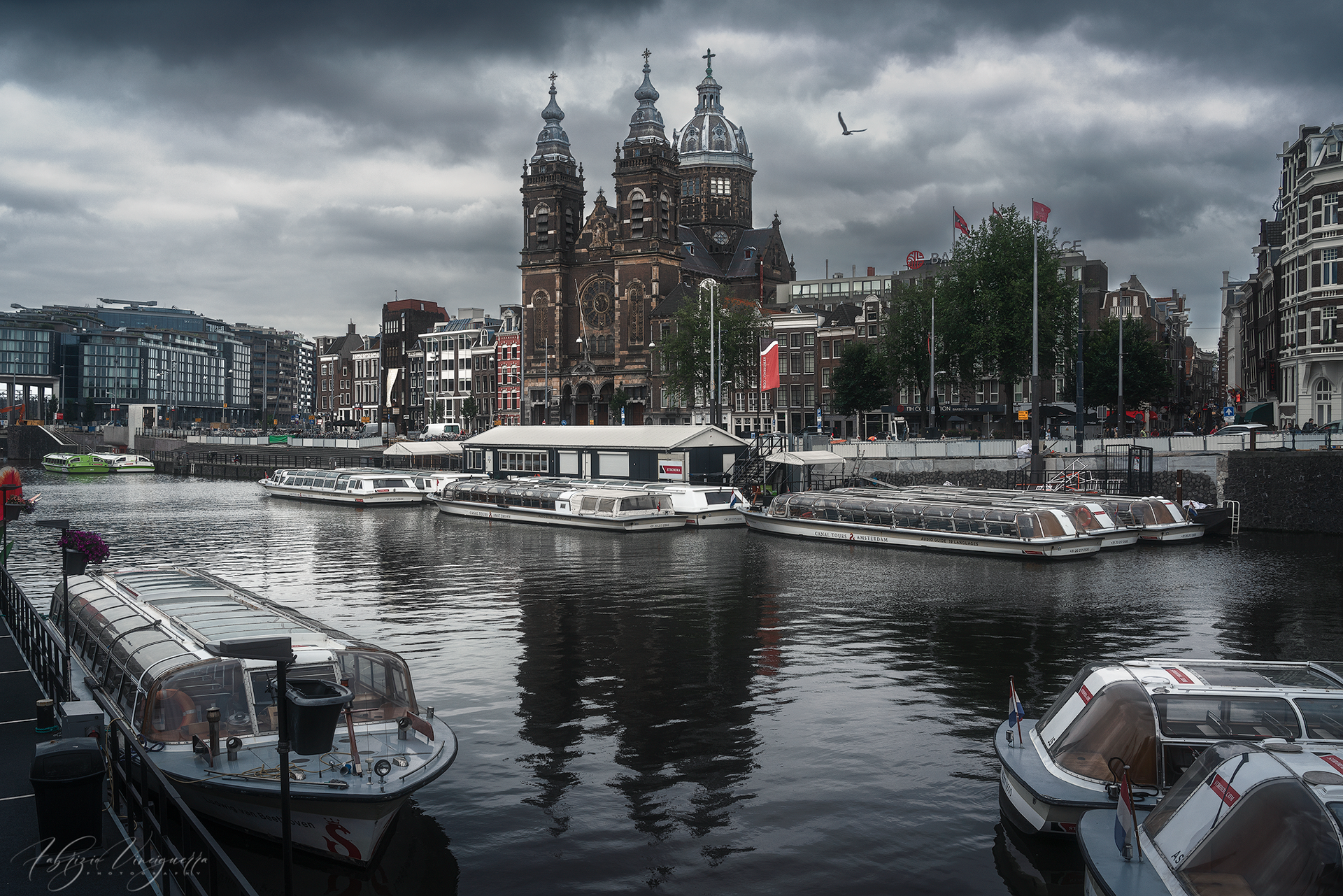 Porto con barche e città sullo sfondo – Un momento di tranquillità nella vita frenetica della capitale, con le barche ormeggiate in primo piano che trasmettono un senso di quiete.