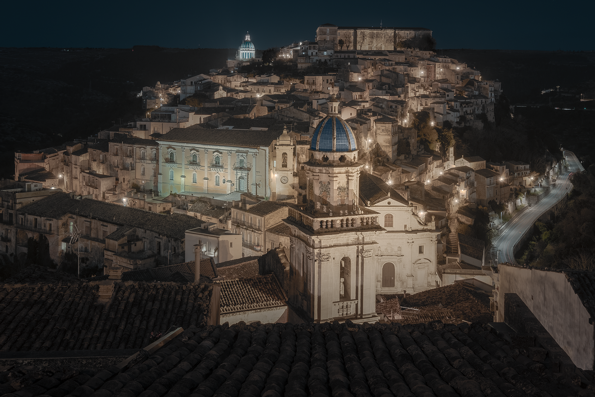 Ragusa Ibla, uno dei gioielli barocchi della Sicilia, illuminata di notte. Le luci dorate mettono in risalto la splendida architettura e la caratteristica cupola della Chiesa di San Giorgio, creando un’atmosfera suggestiva.