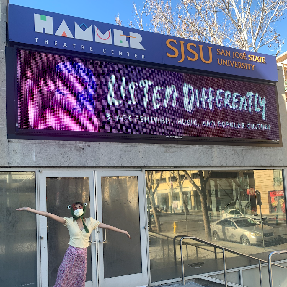 Nimisha, outside of the Hammer Theatre Center, with the Listen Differently electronic banner