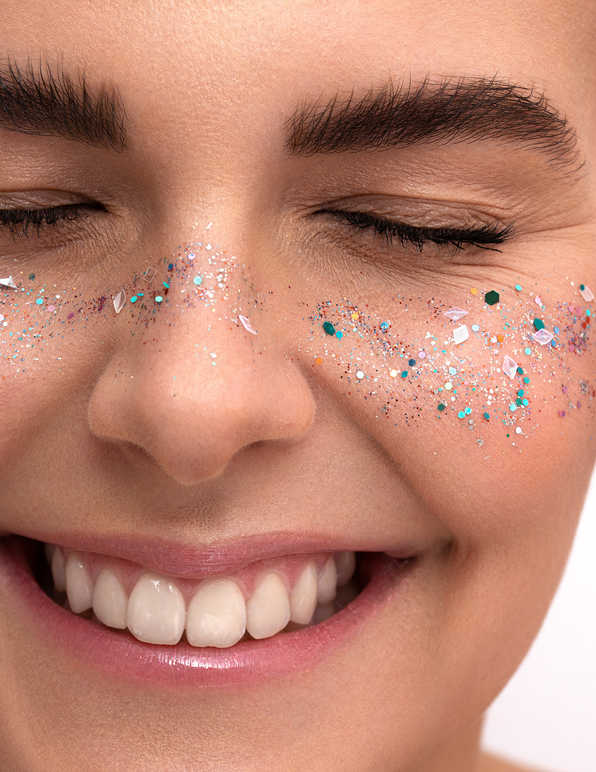 Beautyfotografie, Portrait, Highend Retusche, weißer Hintergund, Glitzer im Gesicht, Lächeln, Closeup
