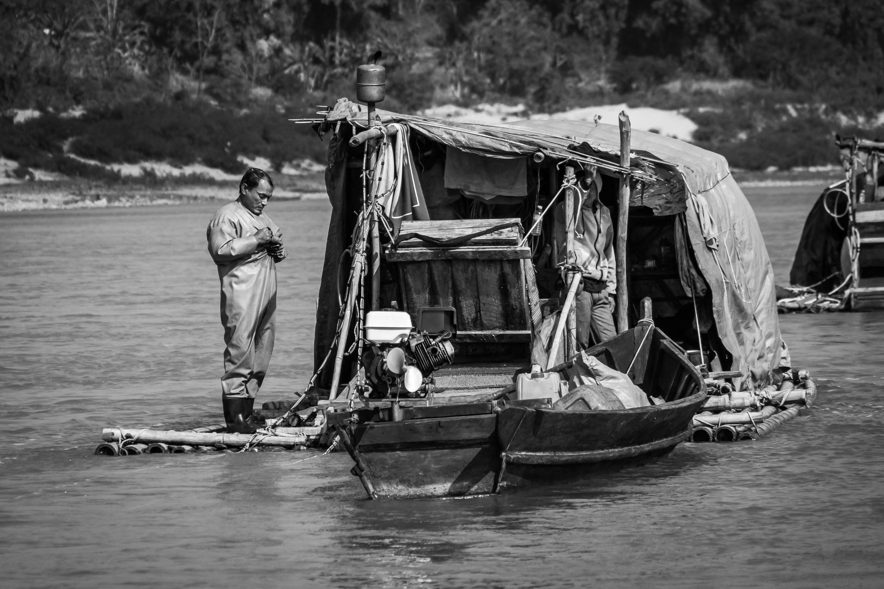 Raft used by local small scale gold divers. The season lasts from December to the end of March. One boat makes in average 60 to 80 USD per day and consists of 2 divers who dive 3-4 hours each, one in the morning and the other in the afternoon while the other stays on the raft. They dive at a depth of 10 to 15m with compressed air. Their equipment is extremely rudimentary and accidents occur frequently. They dive every single day in extremely strong currents and very cold water not exceeding 10-12C. With a large diametre hose they suck soil and sediments from the river bed up to the boat. Mercury, which is very toxic, is being used to make the gold stand out and blink. All the operations are done on the boat. Only people from the nearby villages are allowed to operate small scale gold digging activities, most of them are from the Lazi Kachin minority. Irrawaddy river north of Myitkyina, Kachin State, Myanmar, February 2020