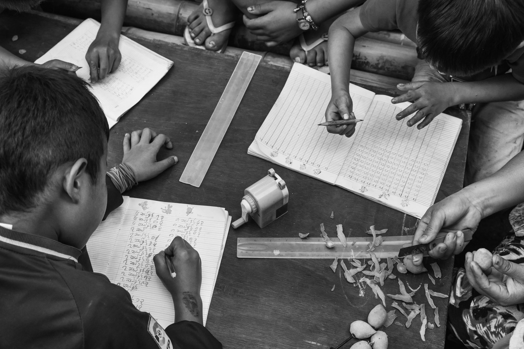 Kachin children doing after school homework in an IDP camp along the border with China in Kachin Independence Army (KIA) held territory in Myanmar. More than 8700 displaced Kachin live in Je Yang camp one hour south of Laiza, the stronghold of the KIA. Je Yang camp in Laiza Township, Myanmar, April 2019