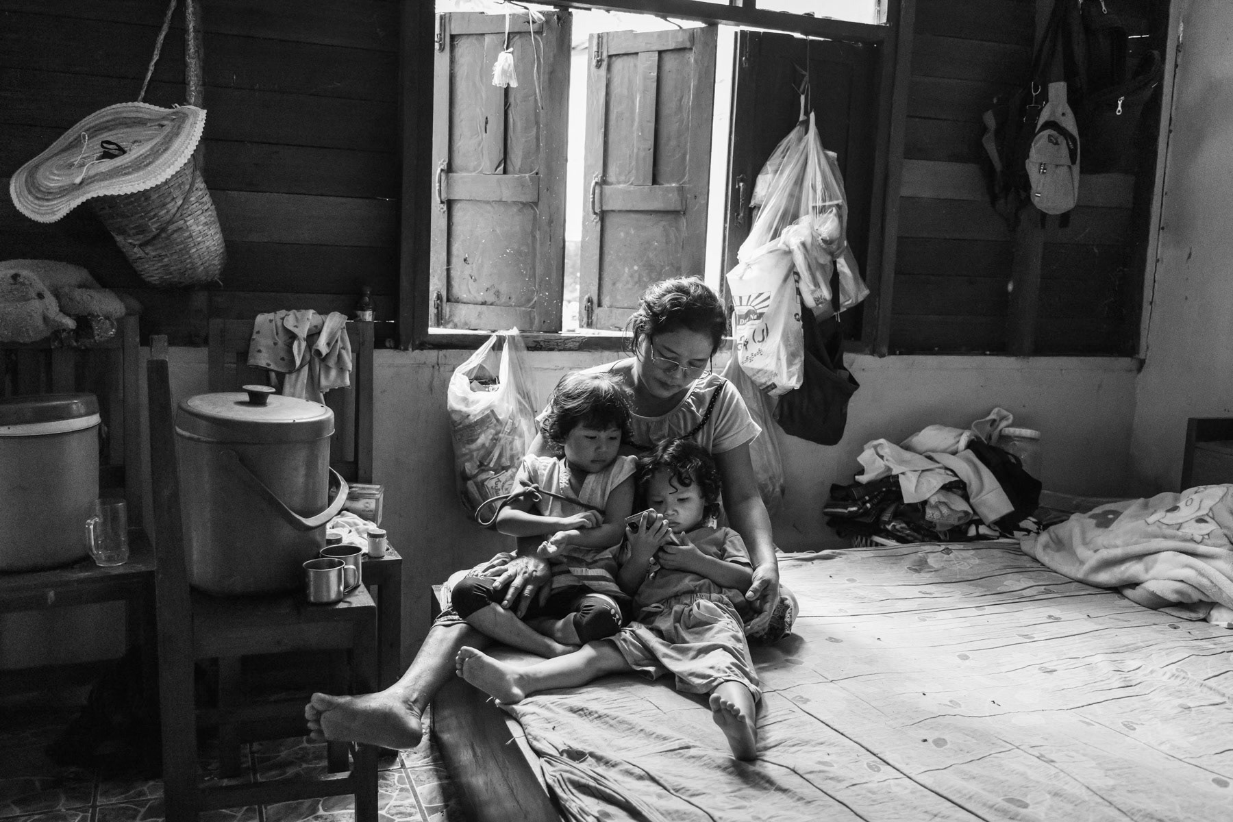 Two and three year old cousins from the Karen ethnic minority living with her family in a rented house just accross the border in Thailand since January 2022. Their village in Myanmar, only 30 km away, was attacked and their house destroyed by air strikes. The Karen population has fled along the border with Thailand where they feel safer against attacks by the Myanmar military but where they live in a precarious situation with all but access to food and medical aid. Ban Pha Dee, Thailand, May 2022