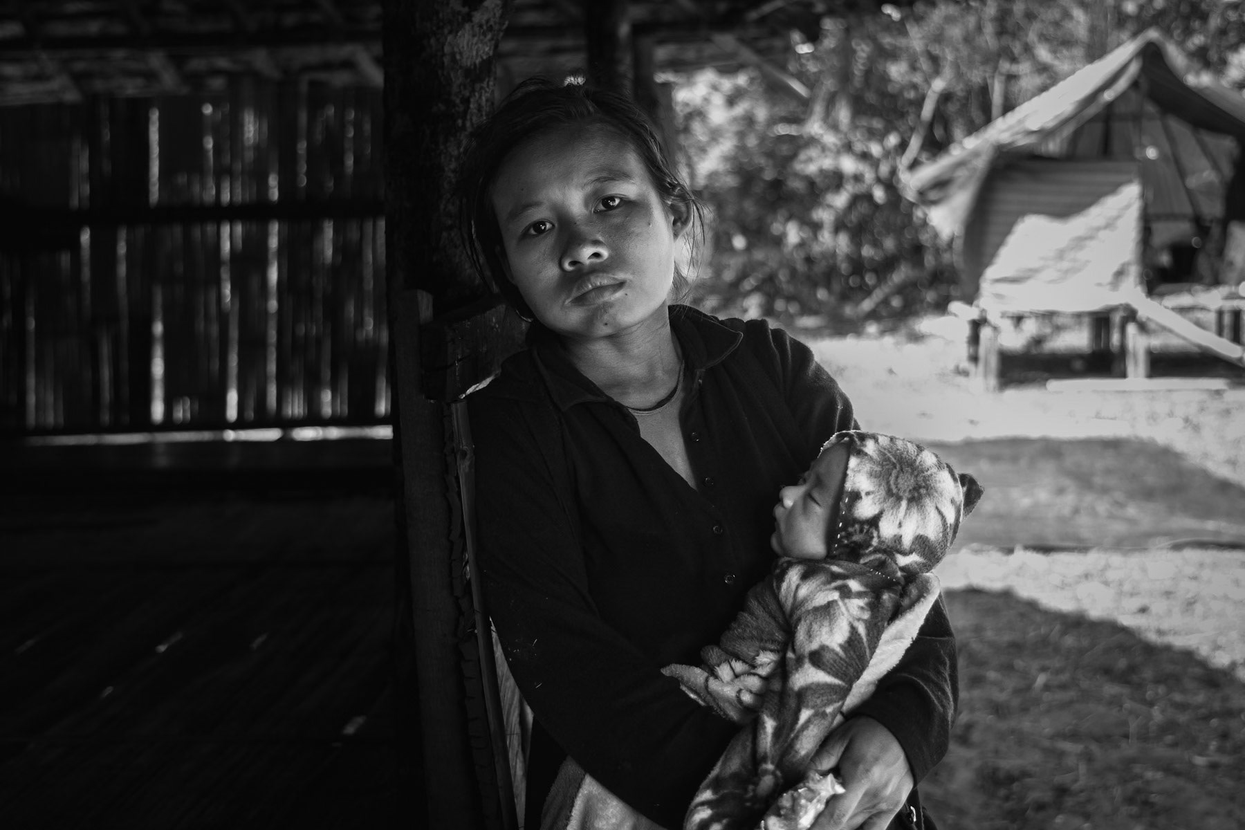 Karen displaced mother and her newborn child in a camp near the Thai border in territory controlled by the Karen National Liberation Army (KNLA). They have fled their village after repeated air attacks by the Myanmar military. Widwspread terror and attacks against civilians and ethnic minorities have substantially increased since the military coup in 2021, provoking large numbers of displaced persons and refugees. Kanele IDP camp, Way Lay, Kayin State, Myanmar. June 2022