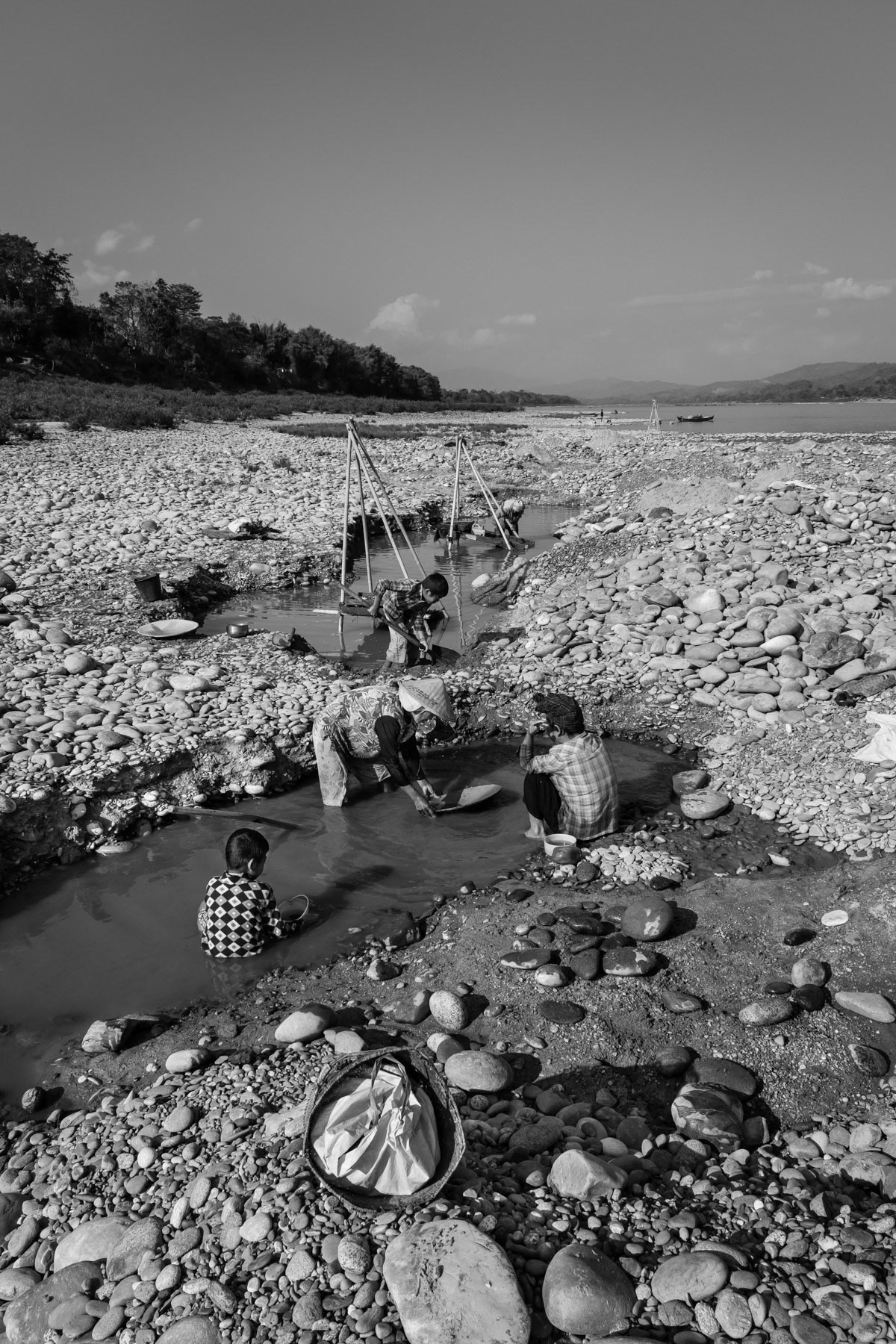 Kachin women from the Lazi ethnic sub-group digging along the shores of the Irrawaddy River to find gold and making in average 5-7 USD a day. They are allowed to do this activity for only a couple of months during the winter season. Lazi villages north of Myitkyina, Kachin State, Myanmar, February 2020