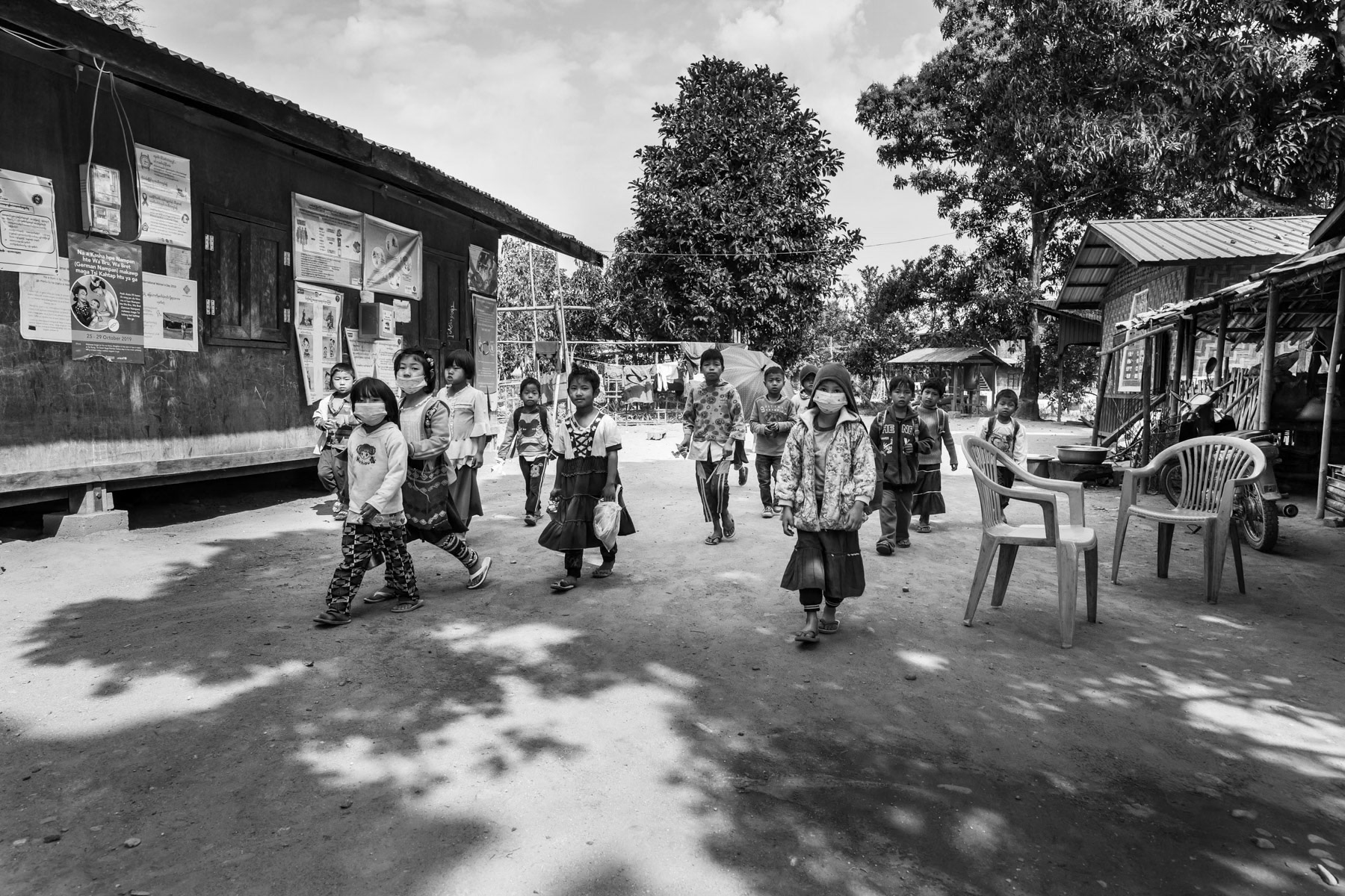 Kachin children returning from school and some wearing a mask at the begining of the Covid19 pandemic when the virus was raging in neighbouring China only 50 km from Momauk. IDP Camps throughout Kachin State host over 100,000 displaced persons since the armed conflict resumed in 2011 between the Myanmar military and the Kachin Independence Army (KIA). Momauk township in government controlled territory Myanmar, January 2020