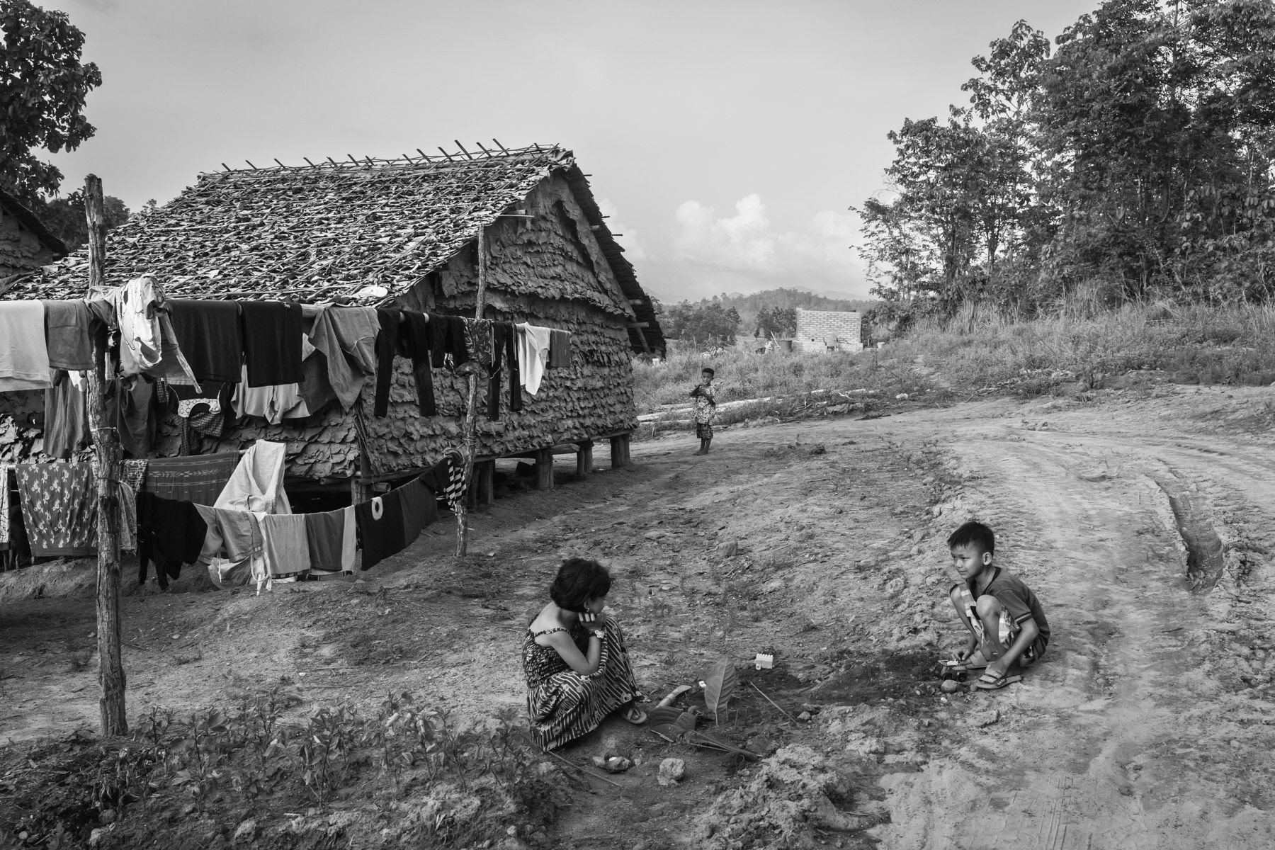 Karen displaced children in front of their recently built shelter near the Thai border. Thousands of civilians have fled since end 2021 the widespread terror and attacks orchestrated by the military junta that took over power in Myanmar. Lae Gho IDP Camp, Kayin State, Myanmar, June 2022