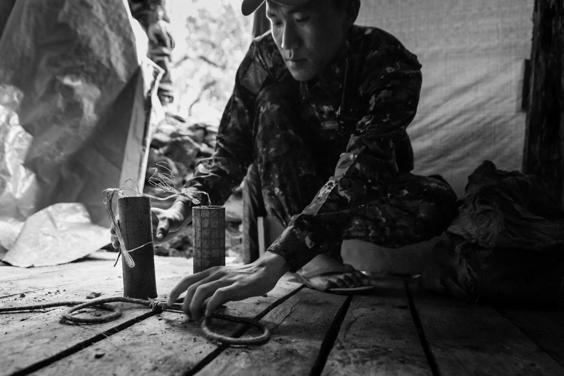 Member of the Chin Defence Force verifying a self-made fragmentation landmine with wire trigger. Lautu region in Chin State, Myanmar, September 2022