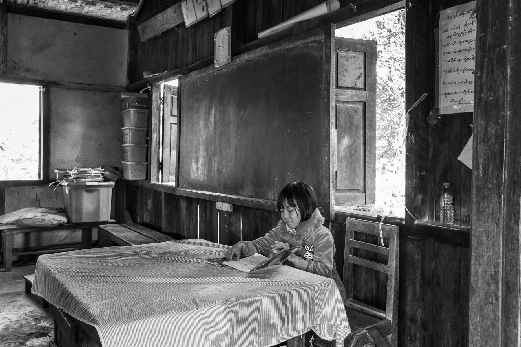 Kachin girl going through her school notes. Robert IDP Camp hosting 4000 internally displaced persons (IDP) of the Christian Kachin Minority. Over 100,000 Kachin are still displaced within Kachin State since the armed conflict resumed in 2011 between the Myanmar military and the Kachin Independence Army (KIA). Bhamo township in government controlled territory Myanmar, January 2020