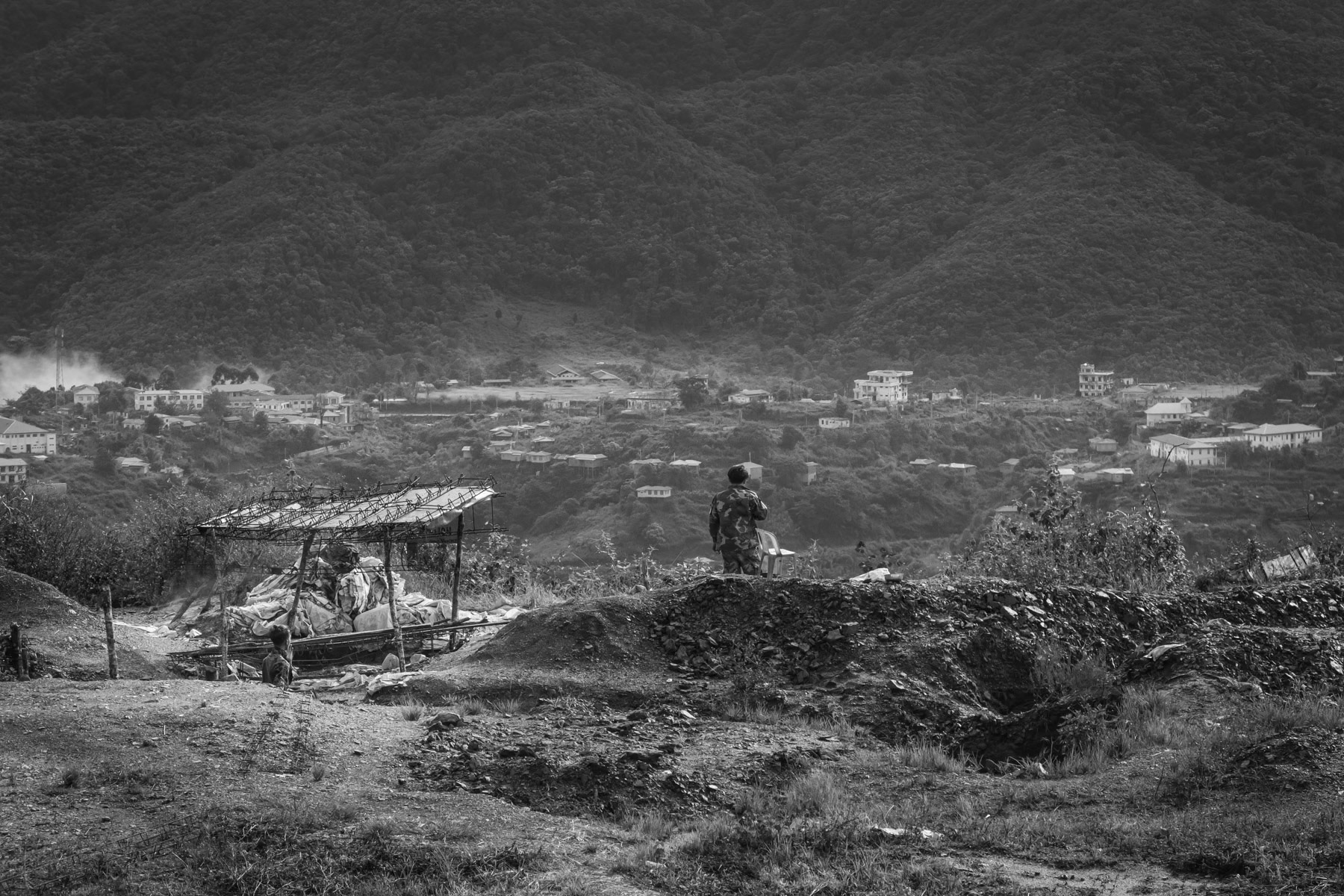 Thantlang town seen from the Chin Defence Forces (CDF) position in the mountains. Thantlang was burnt to the ground by Tatmadaw, the Burmese military in September 2021. The civilian Chin population fled and now the city is divided in two between the Chin Forces on one side and the Myanmar military in the area around their base. CDF positions overlooking Thantlang, Chin, Myanmar, September 2022
