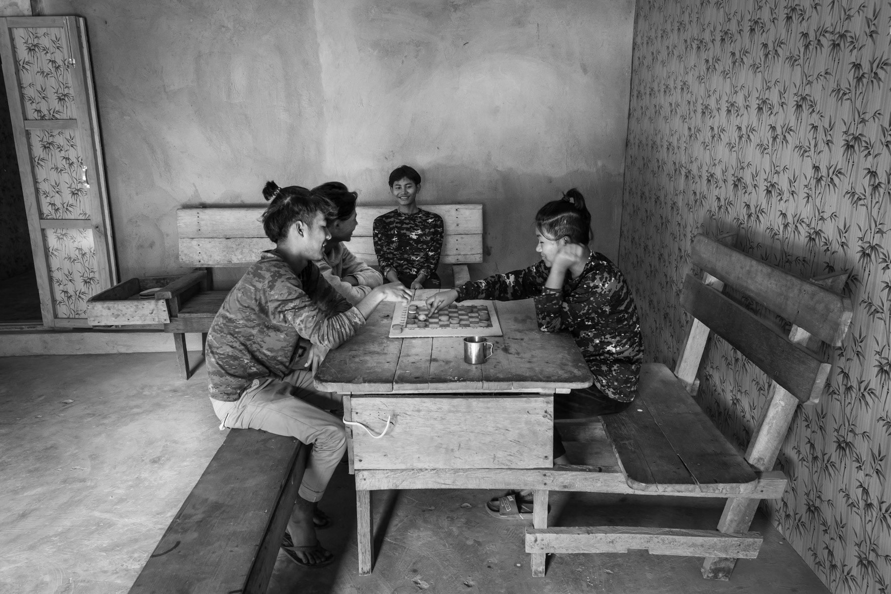 Young Chin National Defence Forces (CNDF) playing a board game during their time off. CNDF HQ in an undisclosed location in Falam, Chin State, Myanmar, November 2022