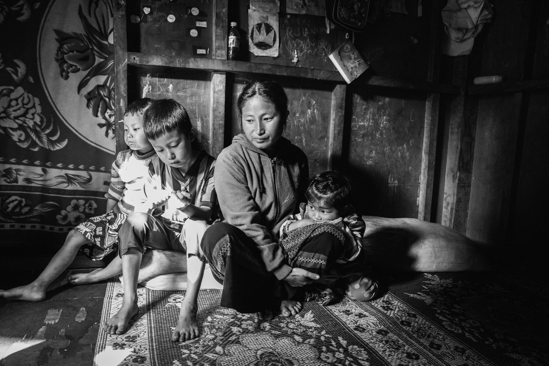 Five year old child on the far left with his siblings and mother; has liver and long problems caused by malnutrion and nutritional defeciencies. A lot of IDP families cannot afford to buy regularly vegetables, fruit and meat causing often nutritional, vitamin and iron deficiencies causing further disease. Food prices are extremely high due to a humanitarian delivery lock down orchestred by the Burmese military and a closed Chinese border for humanitarian convoys. Woichyai IDP camp near Laiza in KIA held territory, Myanmar along the Chinese border, April 2019