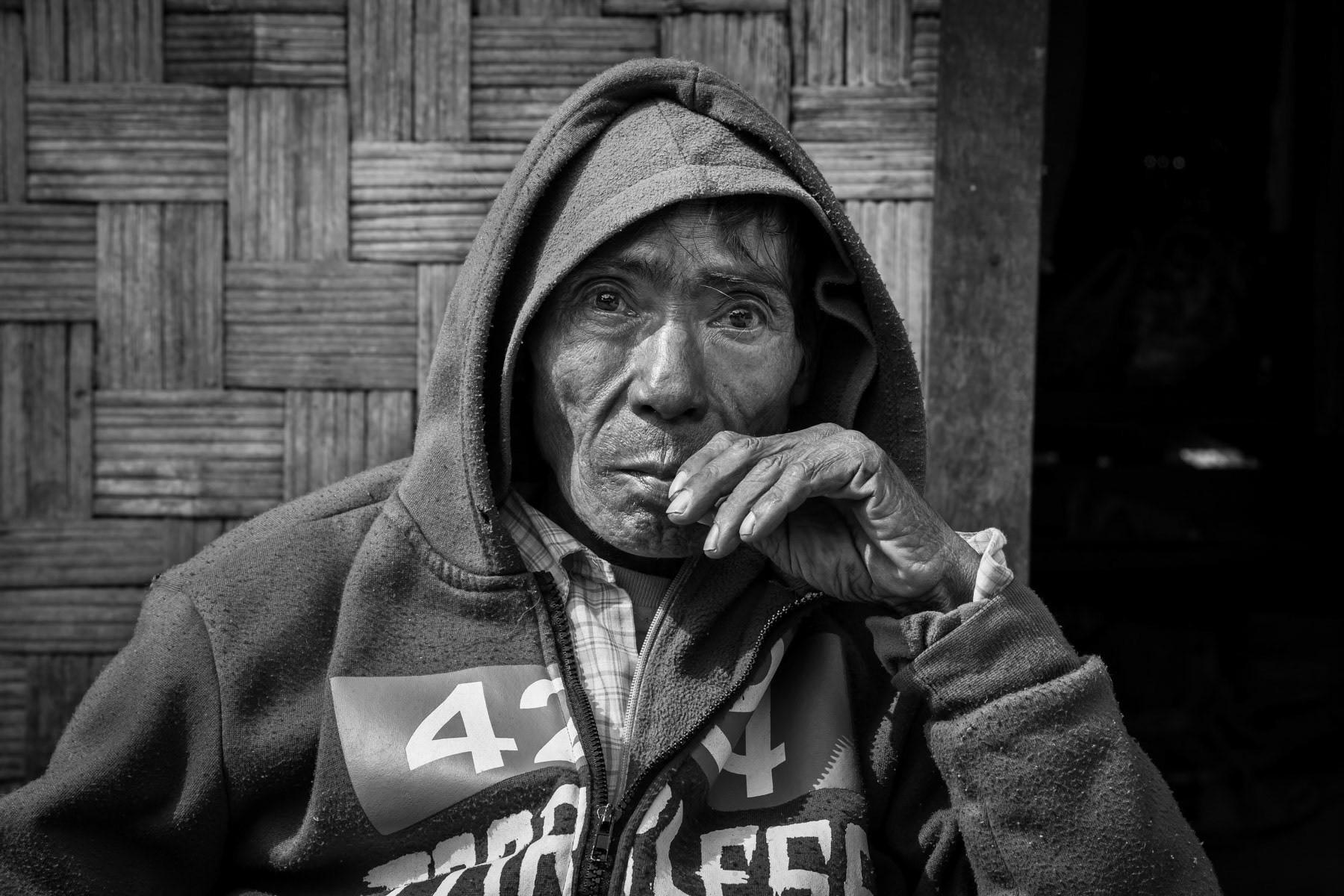 An IDP in front of his shelter at the KBC Compound IDP Camp hosting 430 internally displaced persons (IDP) of the Christian Kachin Minority. Over 100,000 Kachin are still displaced within Kachin State since the armed conflict resumed in 2011 between the Myanmar military and the Kachin Independence Army (KIA). Momauk township in government controlled territory Myanmar, January 2020