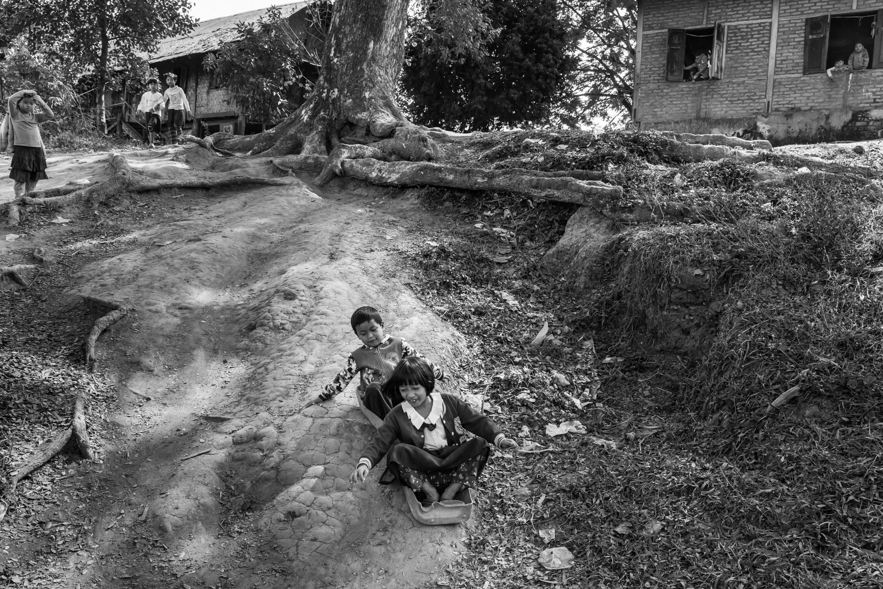 Children playing with an improvised sledge in an IDP camp hosting over 4000 displaced persons. Robert IDP Camp in Bhamo Township, Kachin State, Myanmar, January 2020
