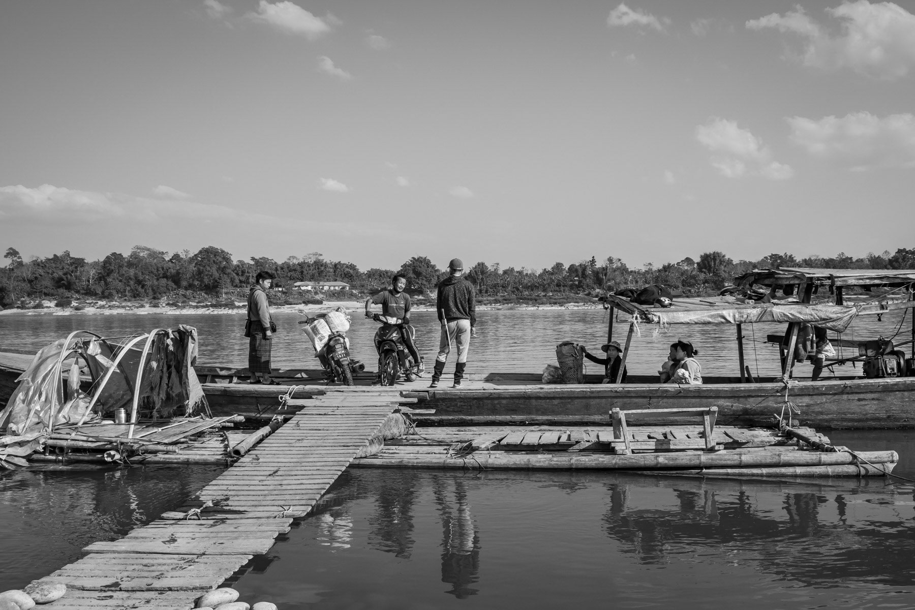 A ferry boat taking passengers and their motorbikes accross the Irrawaddy river 30 Km north of the State capital and the nearest bridge. Myitkyina Township. Kachin State, Myanmar, February 2020