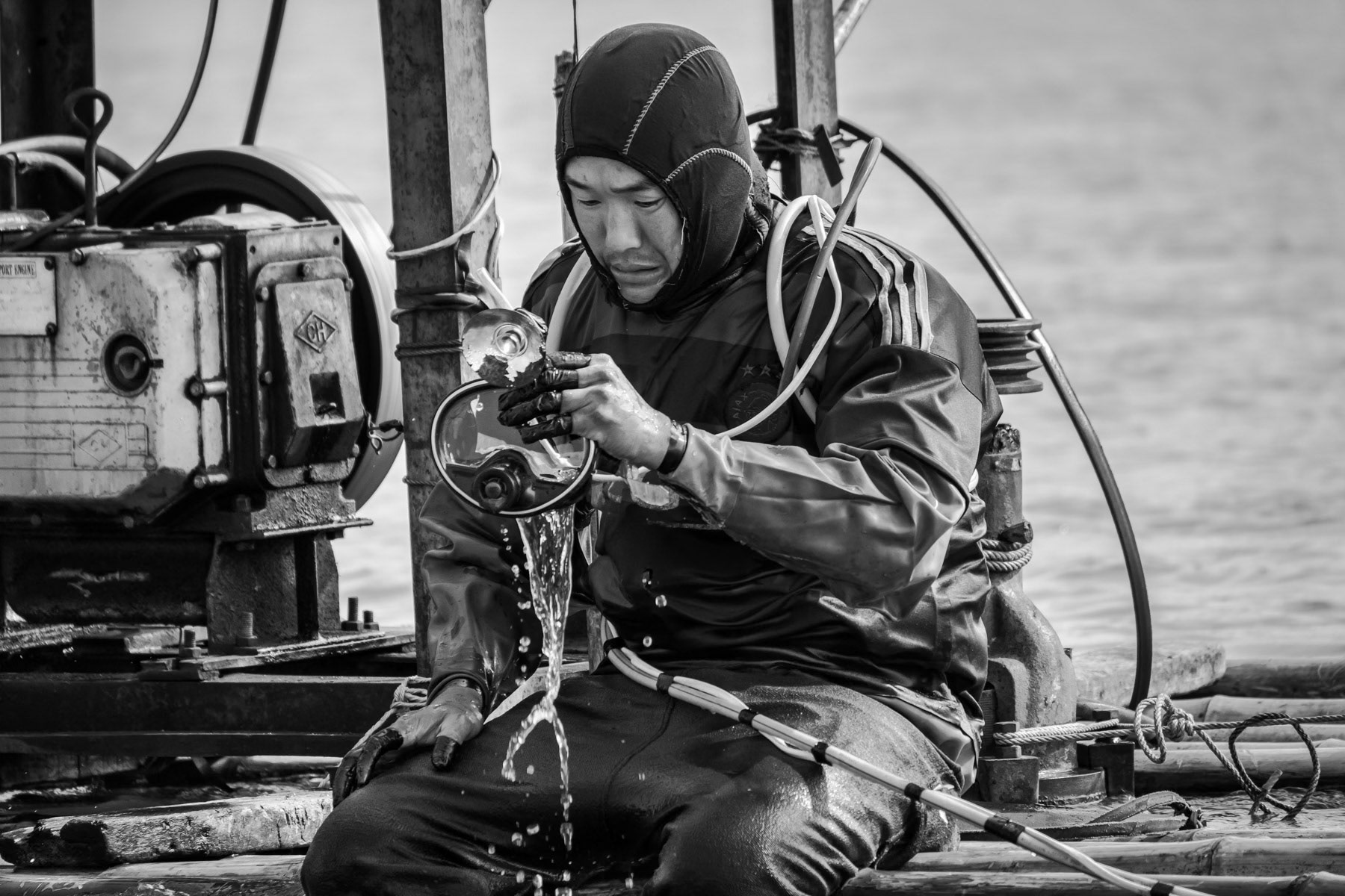 A gold diver getting ready to dive with compressed air for several hours at a depth of 10 to 15m. The equipment used and air compressor are very rudimentary and unsafe. Accidents and health issues are frequent as divers lack basic diving safety practices and do dive repeatedly every single day for several hours for 3 months in a row. The gold diving season is only allowed from December and March and is for villagers a unique opportunity to make money during the winter months despite the risks. Irrawaddy River north of the Kachin State capital Myitkyina, Myanmar, February 2020