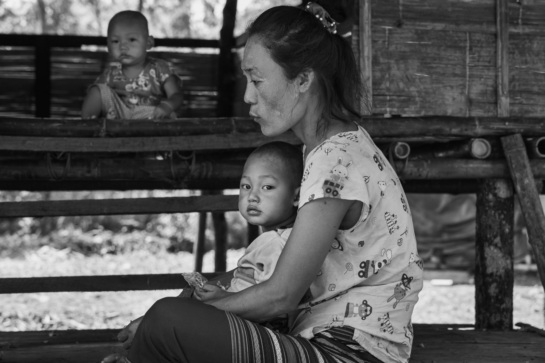 Karen displaced mother and her child in a camp near the Thai border in territory controlled by the Karen National Liberation Army (KNLA). They have fled their village after repeated air attacks by the Myanmar military. Widwspread terror and attacks against civilians and ethnic minorities have substantially increased since the military coup in 2021, provoking large numbers of displaced persons and refugees. Kanele IDP camp, Way Lay, Kayin State, Myanmar. June 2022