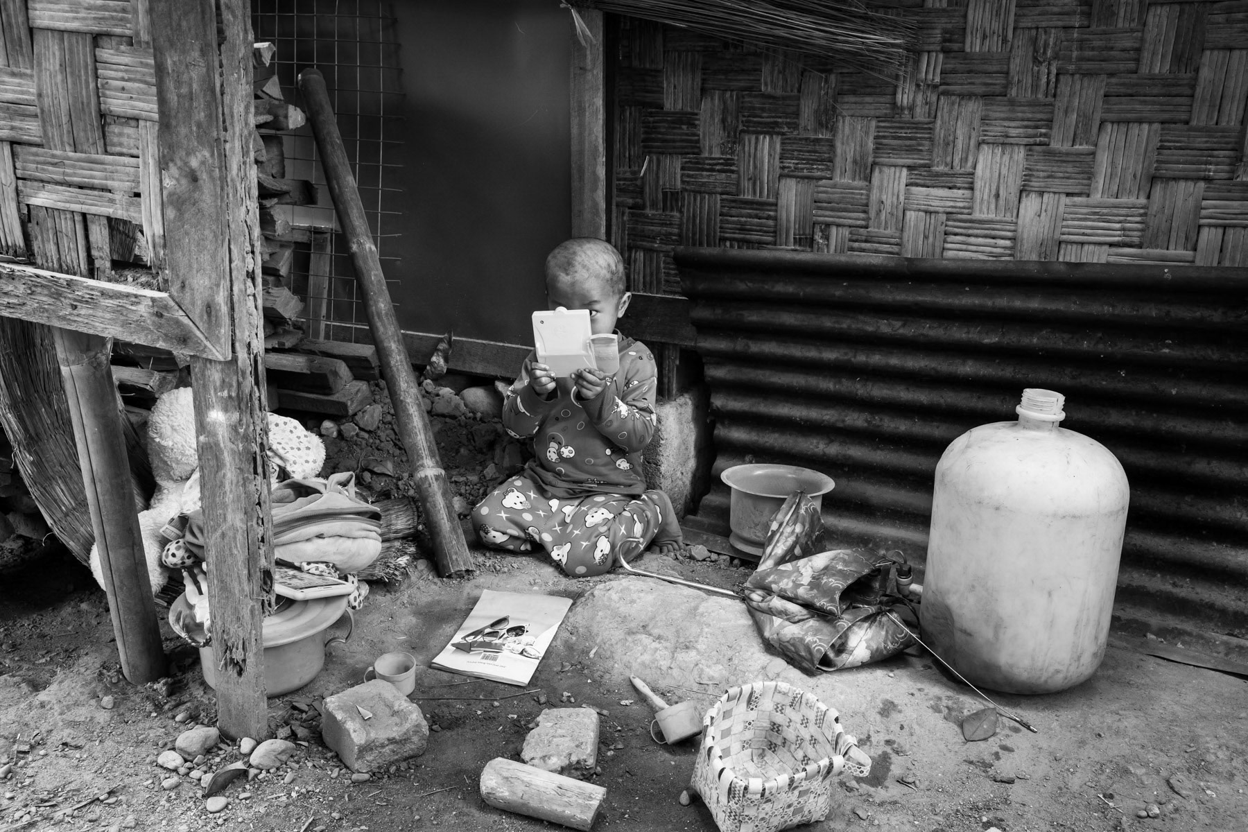 A Kachin child playing in front of her temporary shelter in an IDP Camp in Kachin State. Kachin Baptist Church (KBC) IDP Camp in Momauk, Myanmar, January 2020