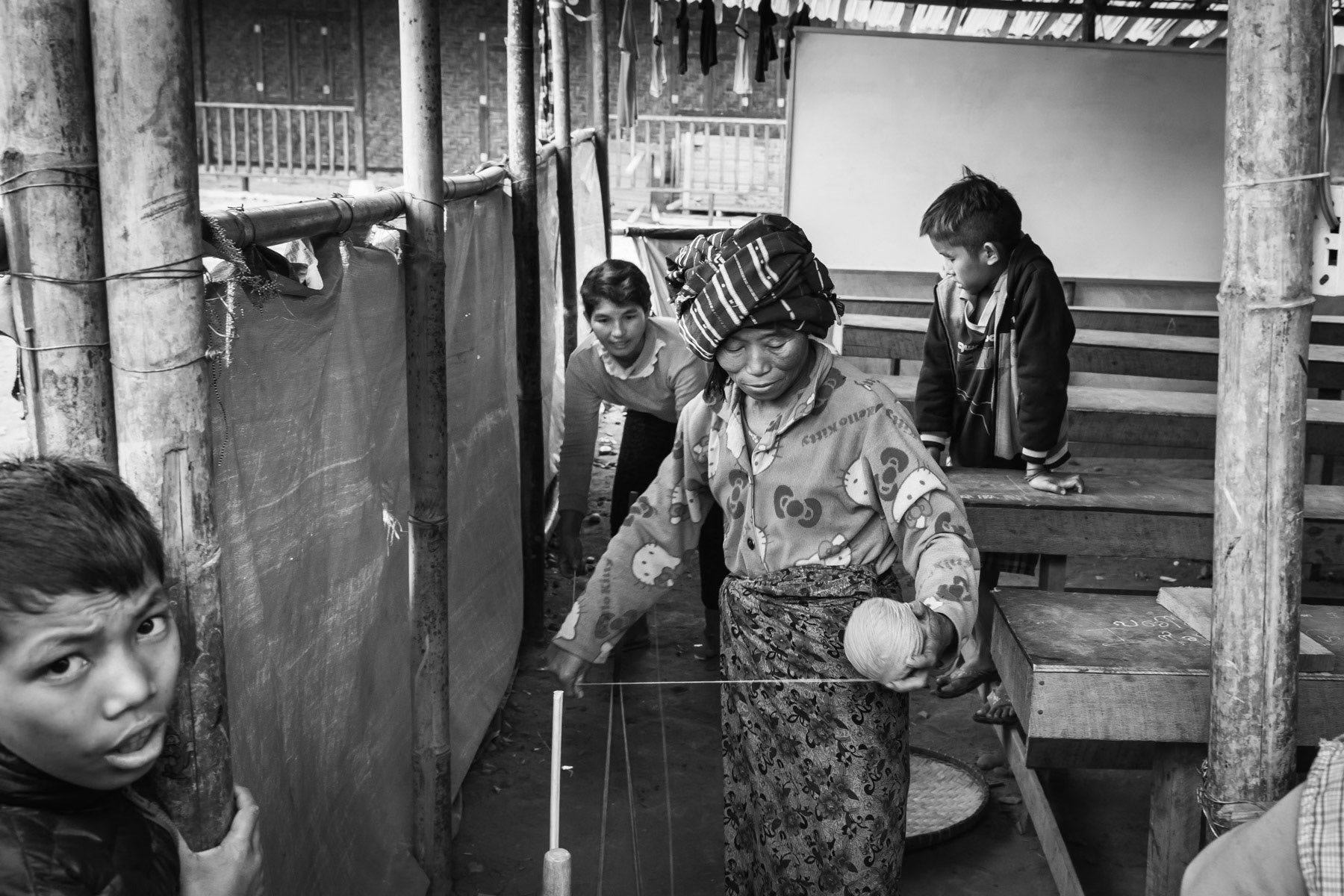 Kachin displaced persons weaving wool for the cold winters. Trinity IDP camp in Myitkyina in Kachin State, Myanmar, February 2019