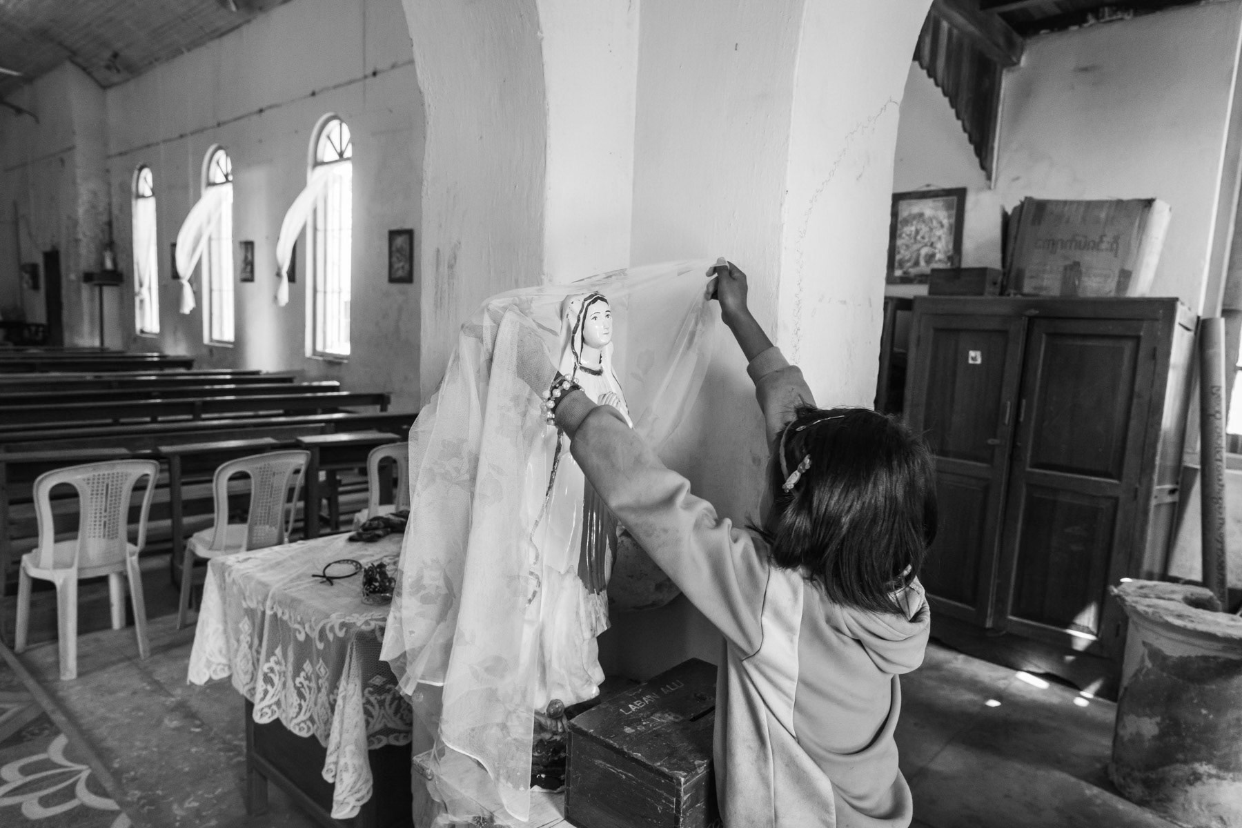 A Kachin girl in the Catholic church of Tang Hpye, a village that was evacuated before the planned Myitsone dam project that will flood the area. People from the village have been resettled in a newly built village 20km away. Kachin State, Myanmar, March 2019