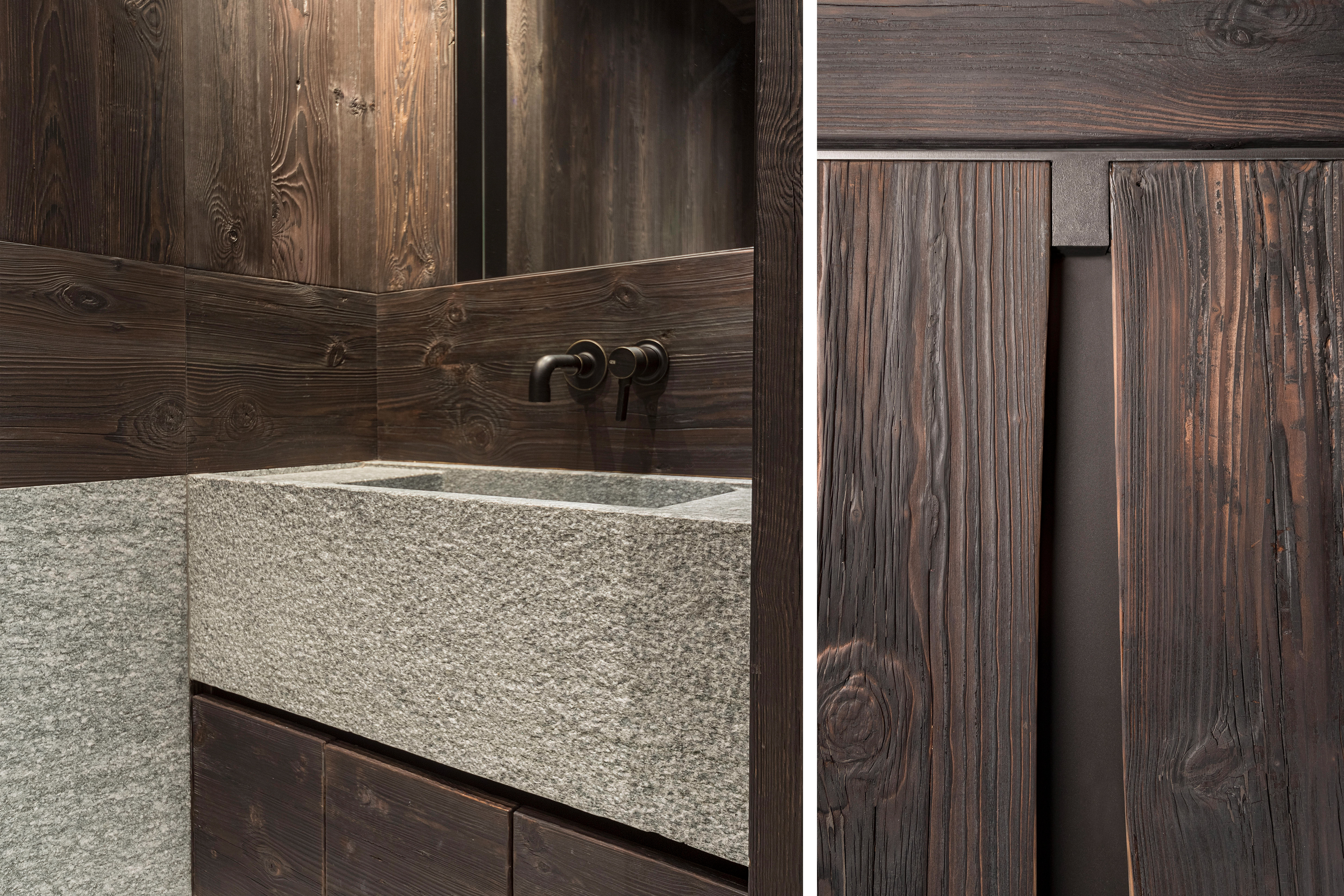 Close-up of a custom stone bathroom sink, complemented by wood accents and bespoke wardrobe handles.