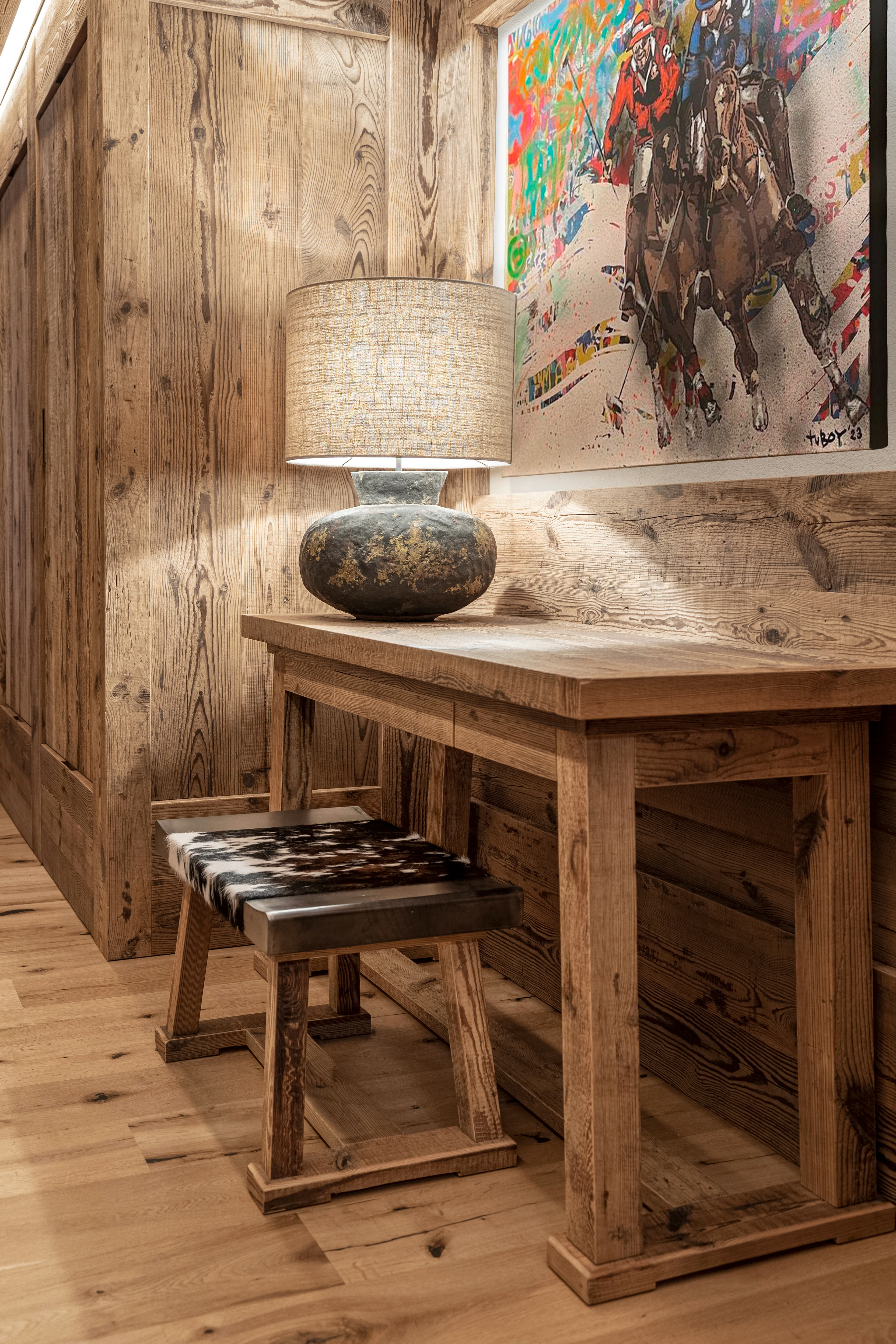 Close-up of an entrance area with a custom-made console table and framed artwork, designed within the boiserie paneling.