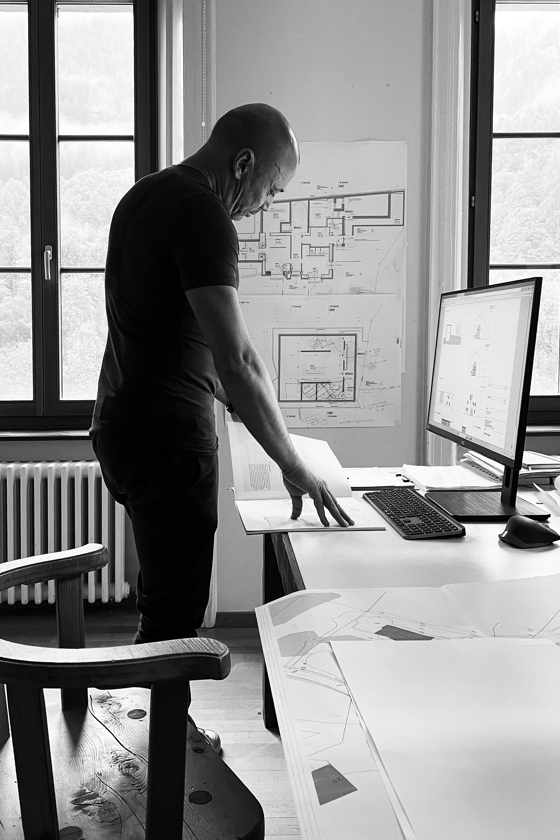 Architect Gianluca Fanetti at work, analyzing and reviewing project drawings.