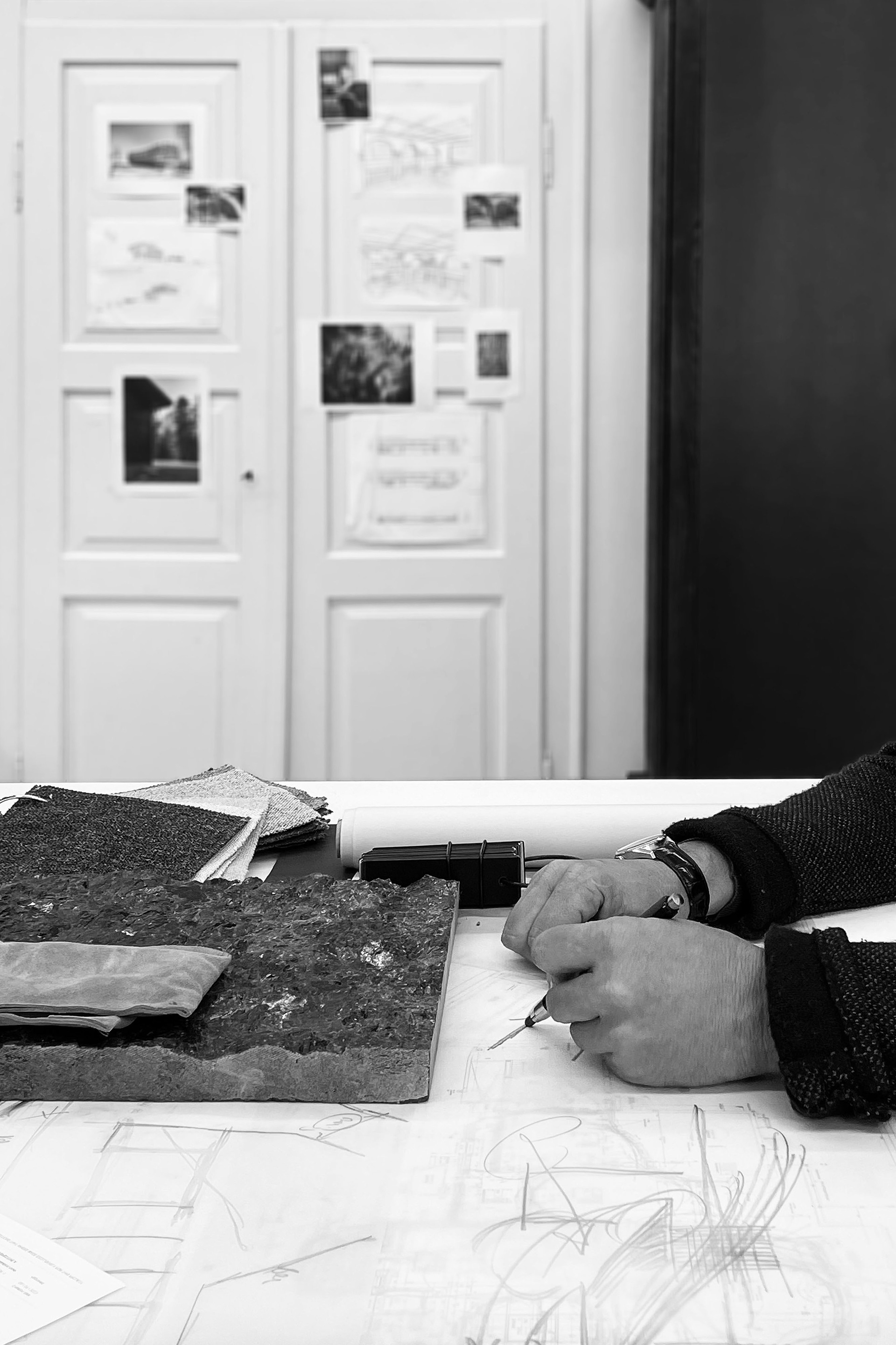 Close-up capturing the creative process of ideation, with hands sketching designs and arranging materials.