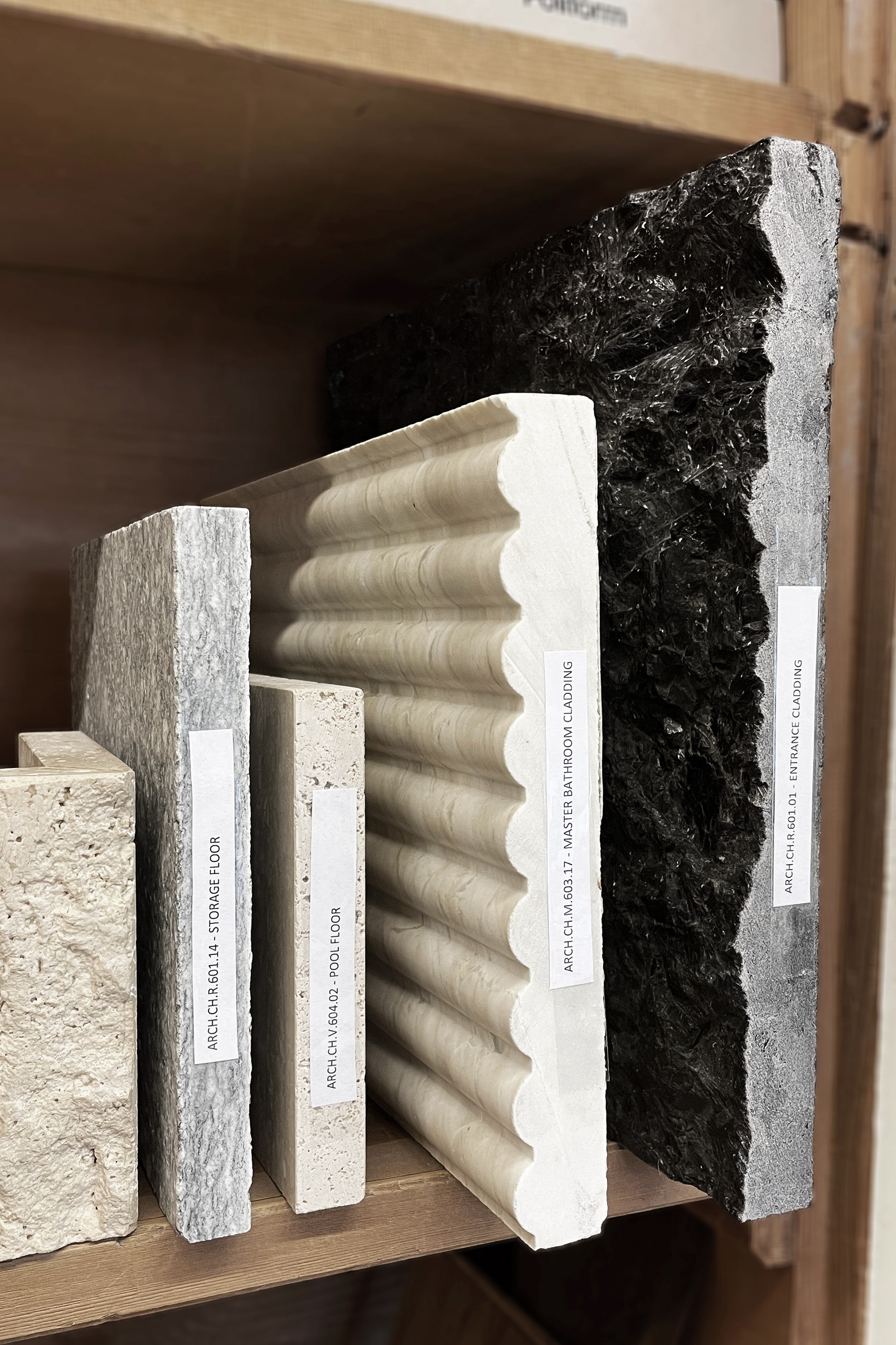 A collection of material samples with labeled codes for various uses in luxury design projects.