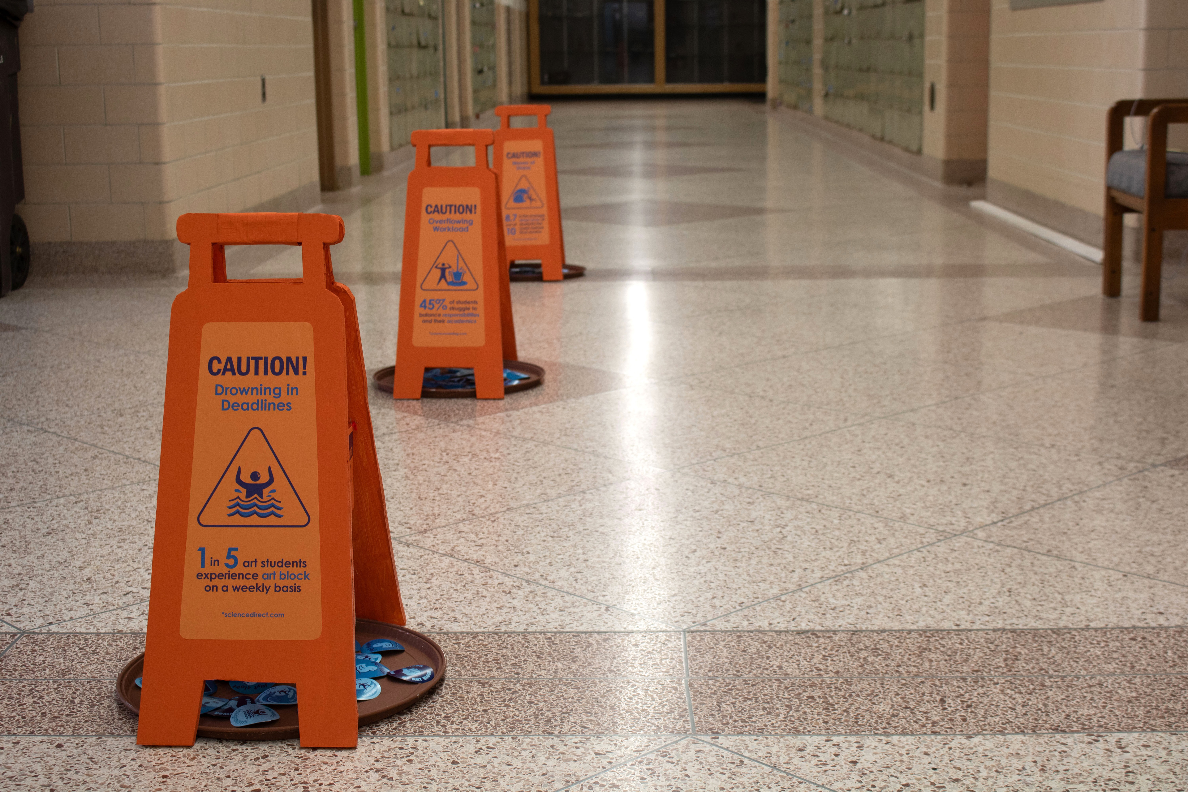Signs placed in a central hallway for maximum visibility.